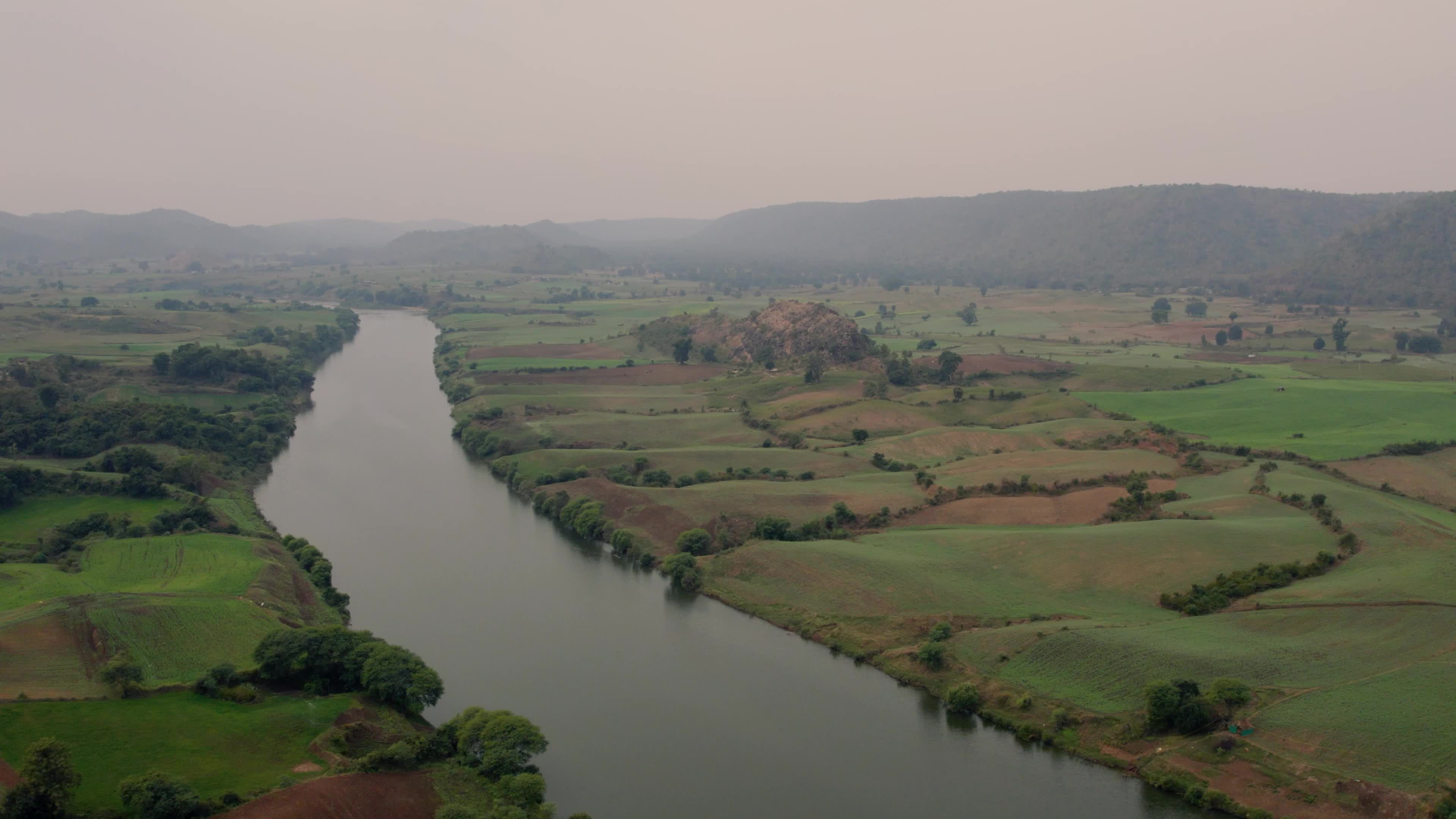 Beautiful drone view of a River surrounded by mountains and fields in the Indian state of Chhattisgarh