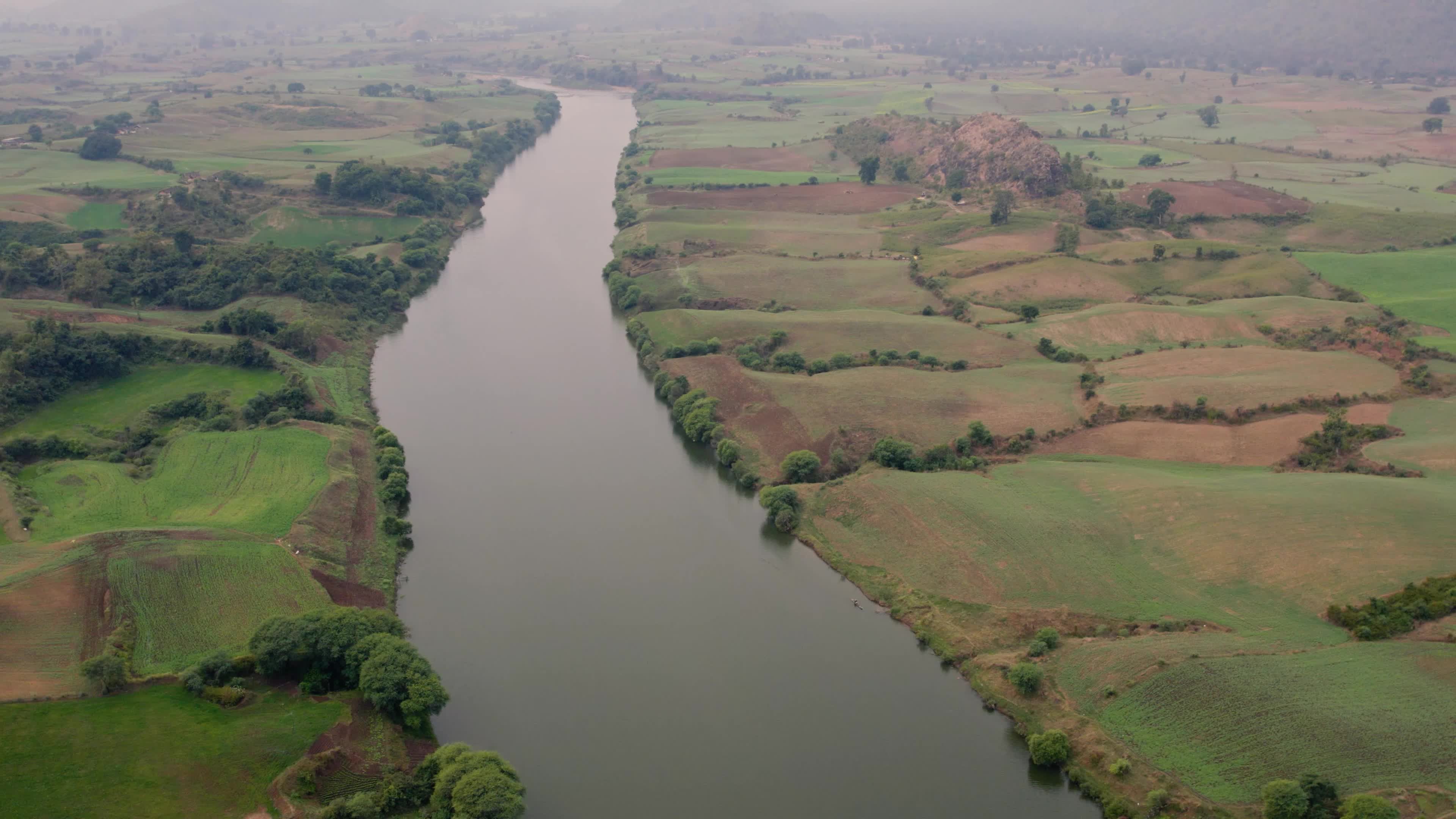 Beautiful drone view of a River surrounded by mountains and fields in the Indian state of Chhattisgarh