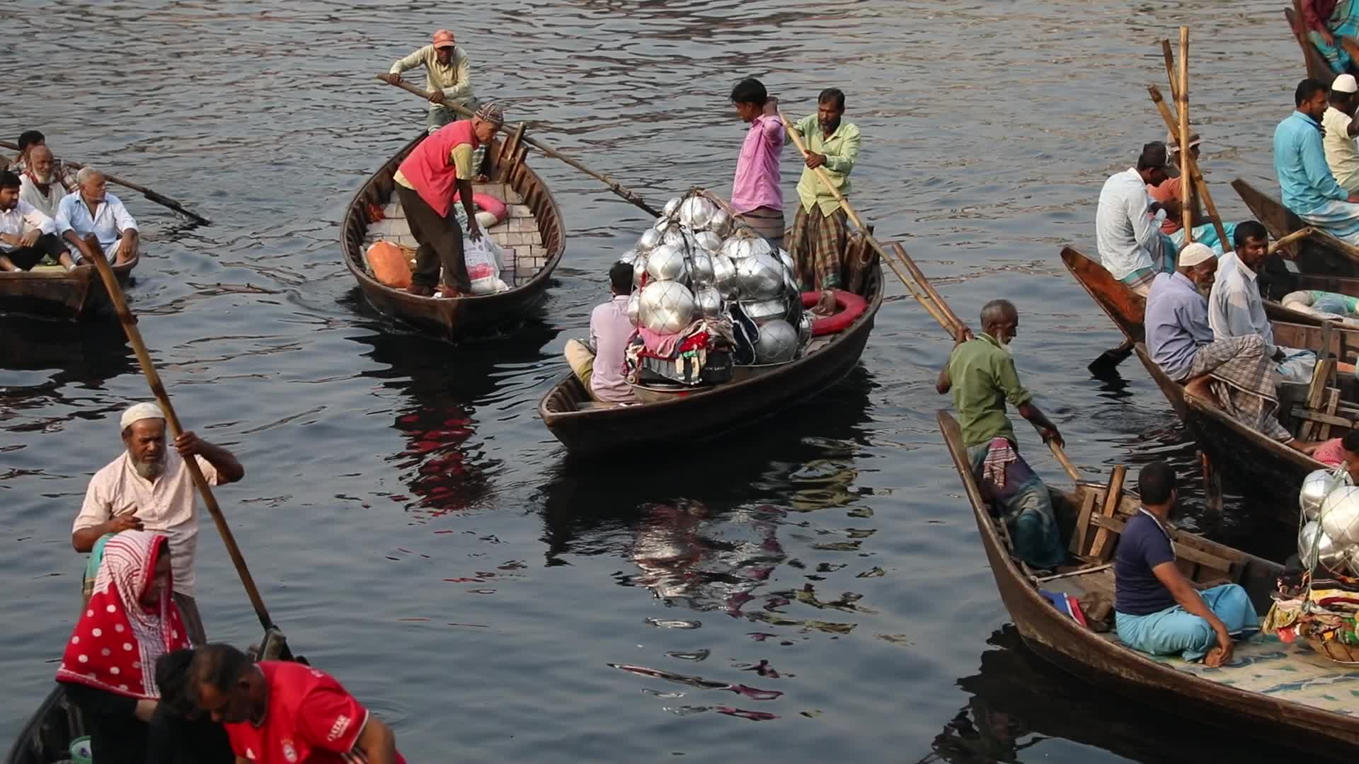 A street vendor carries kitchen utensils in baskets