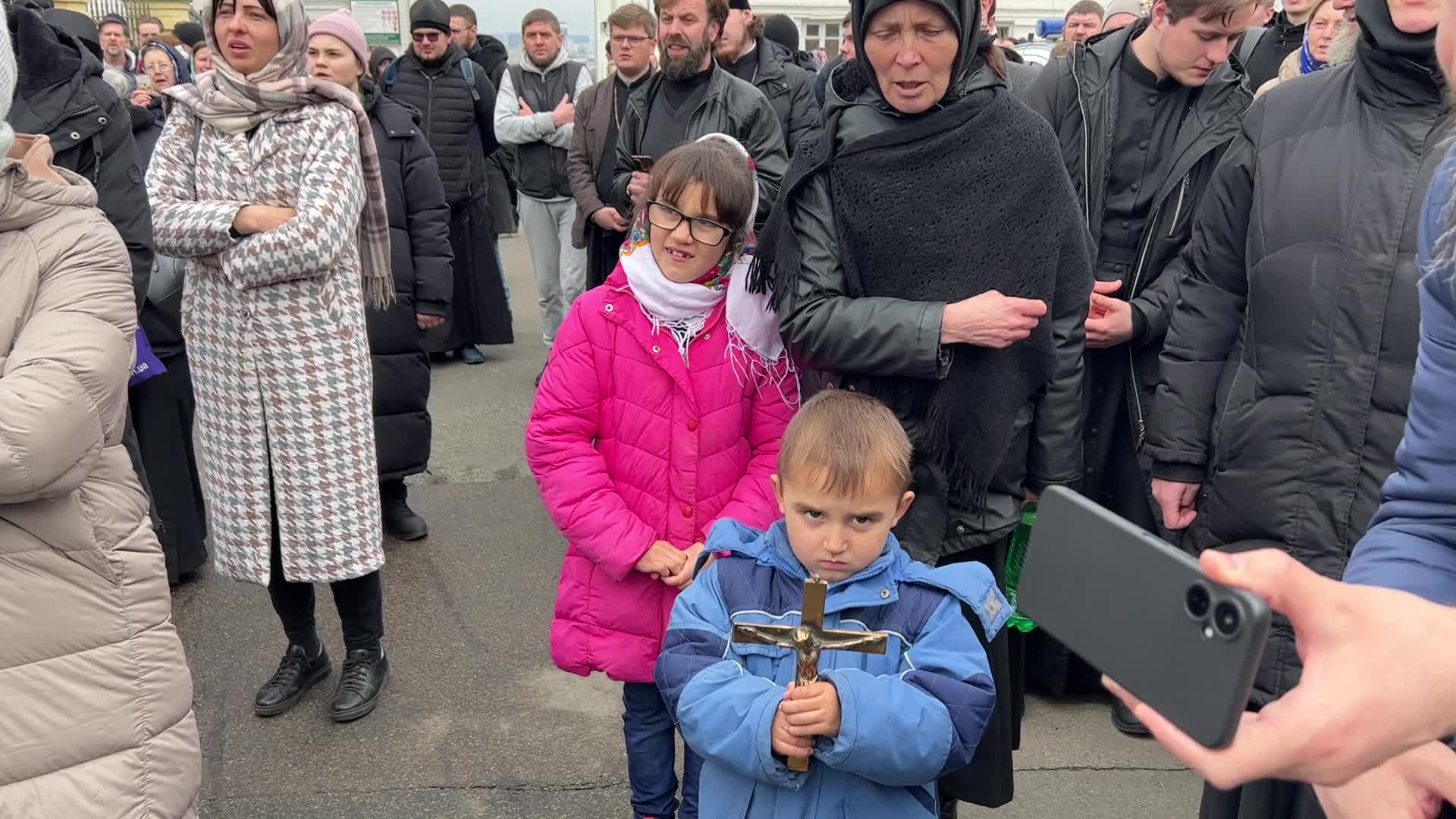 Priests and believers of the Ukrainian Orthodox Church of the Moscow Patriarchate pray while they block an entrance to a church 