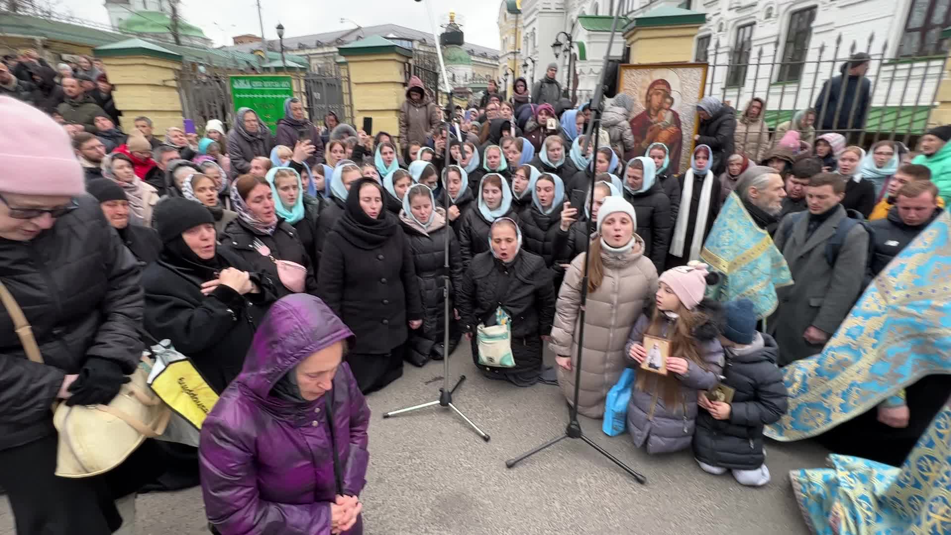 Priests and believers of the Ukrainian Orthodox Church of the Moscow Patriarchate pray while they block an entrance to a church 