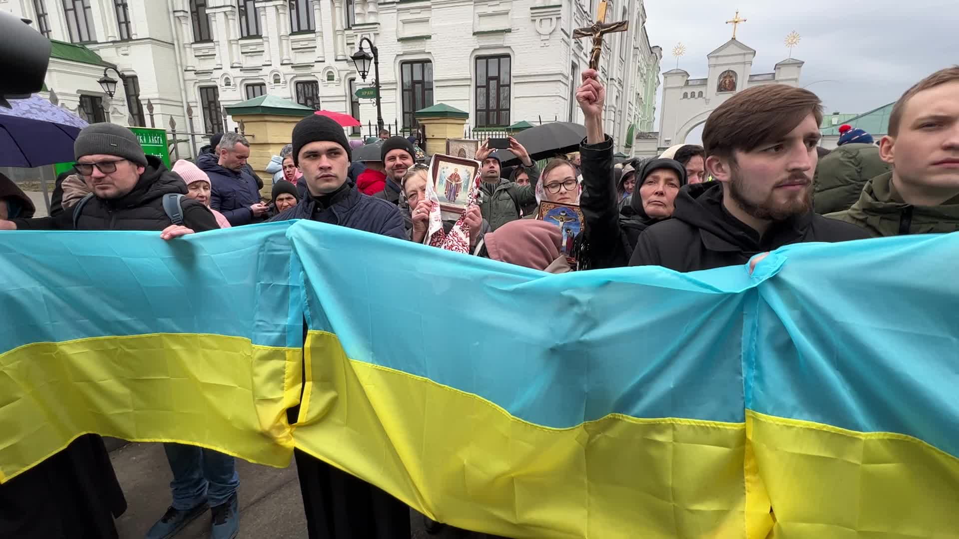 Priests and believers of the Ukrainian Orthodox Church of the Moscow Patriarchate pray while they block an entrance to a church 