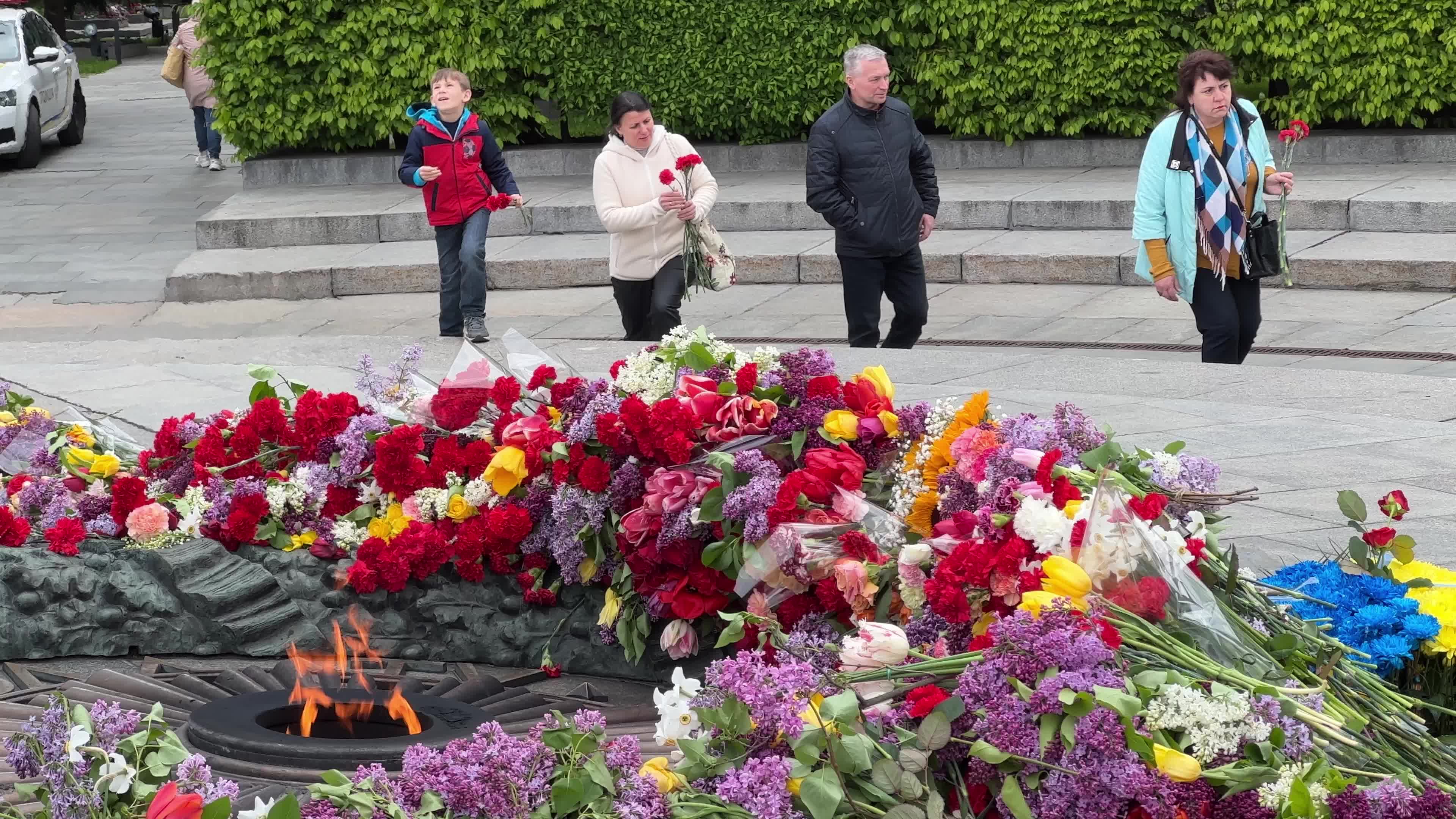 People place floral tributes at the Tomb of the Unknown Soldier monument during Victory in WWII Day commemorations in Kyiv 