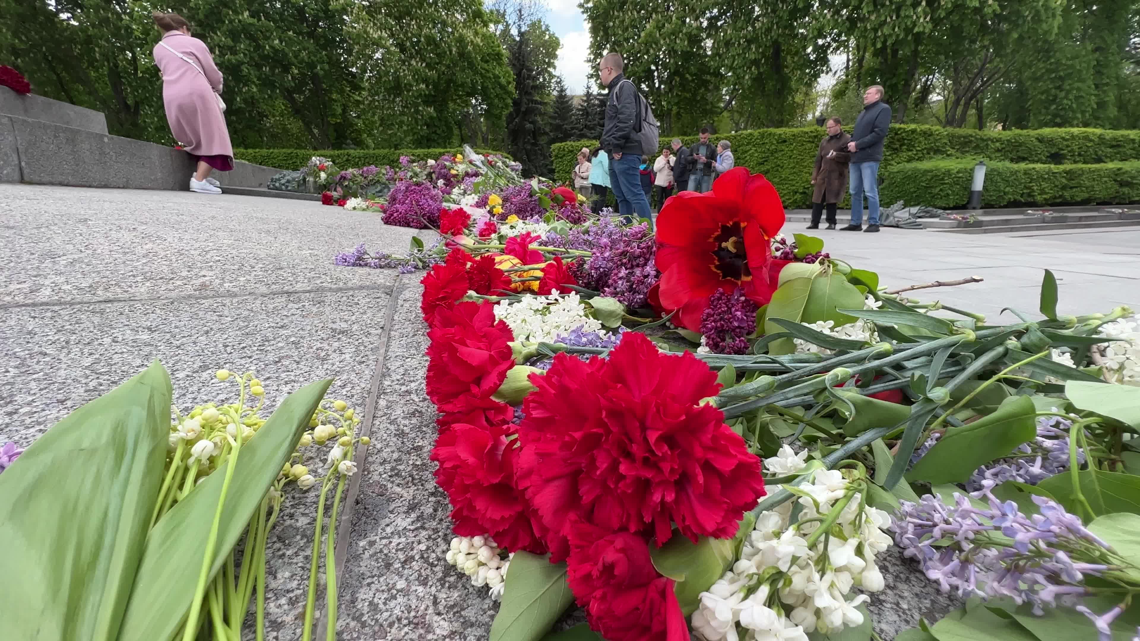 People place floral tributes at the Tomb of the Unknown Soldier monument during Victory in WWII Day commemorations in Kyiv 