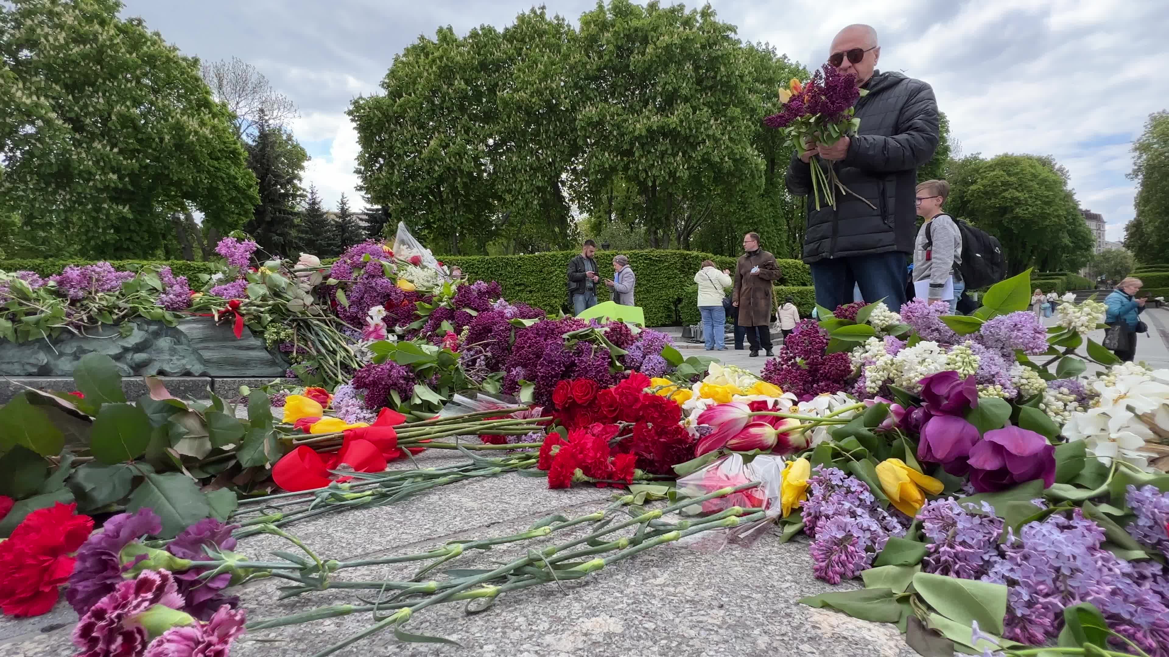 People place floral tributes at the Tomb of the Unknown Soldier monument during Victory in WWII Day commemorations in Kyiv 