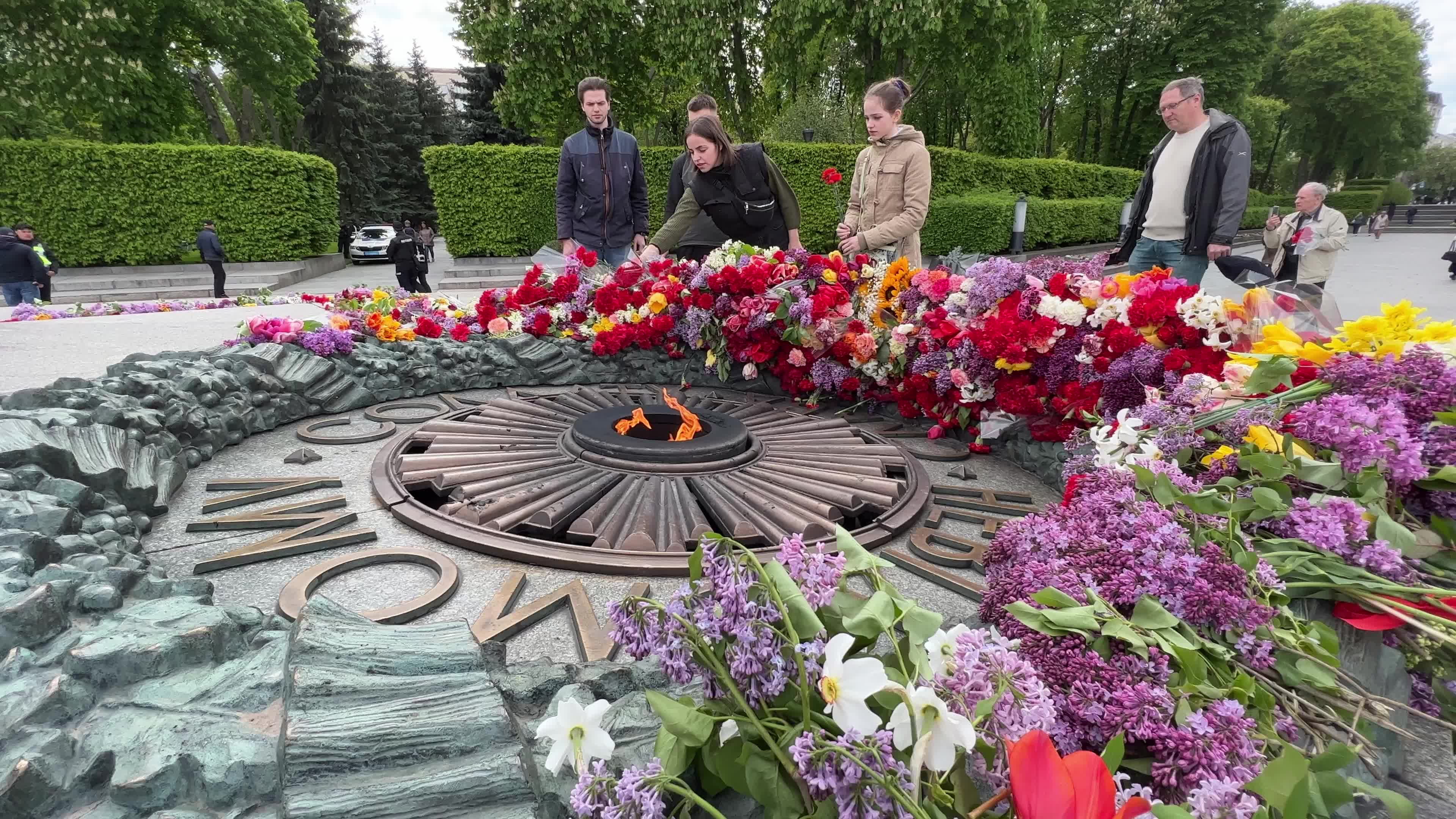 People place floral tributes at the Tomb of the Unknown Soldier monument during Victory in WWII Day commemorations in Kyiv 