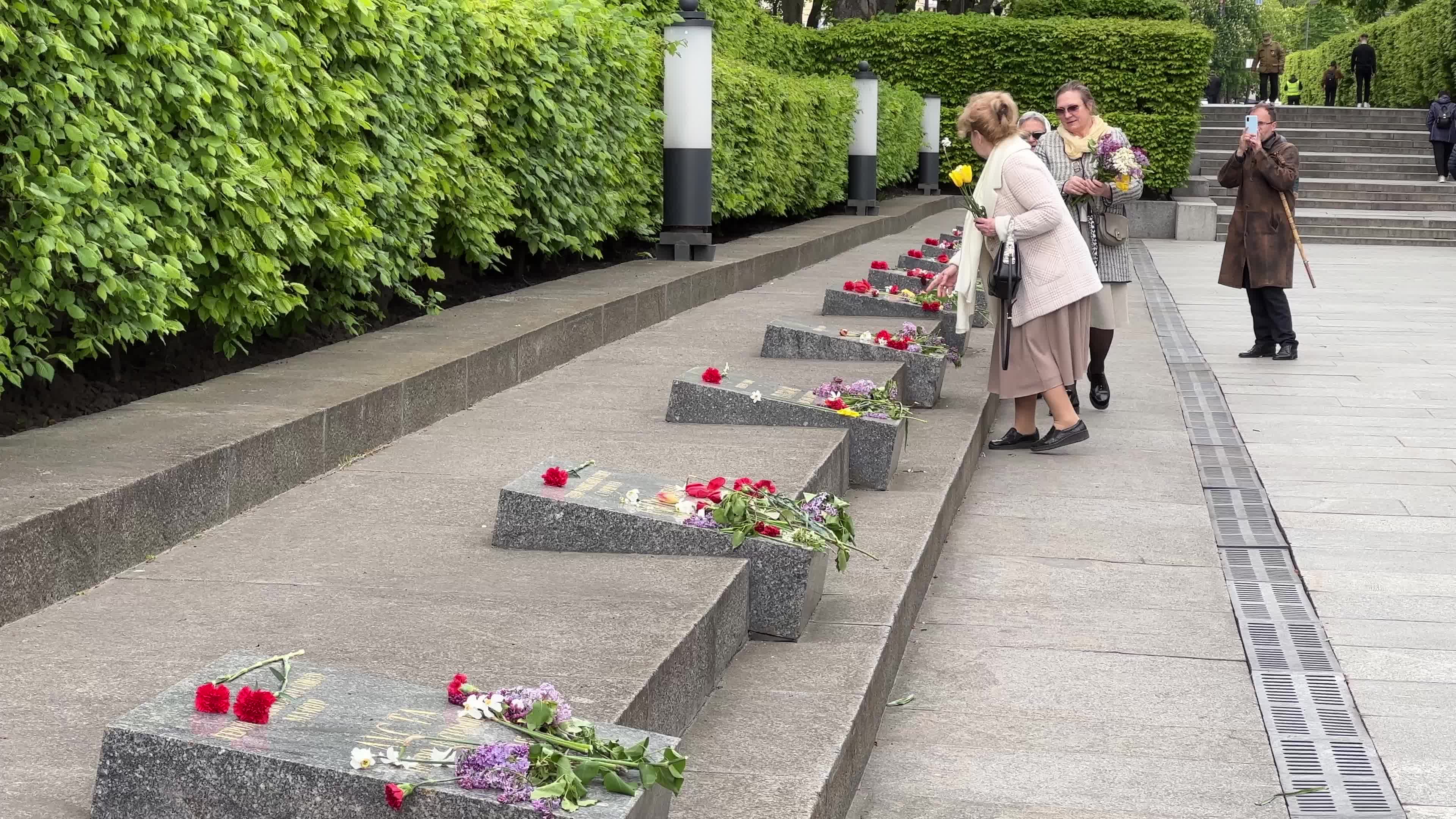 People place floral tributes at the Tomb of the Unknown Soldier monument during Victory in WWII Day commemorations in Kyiv 