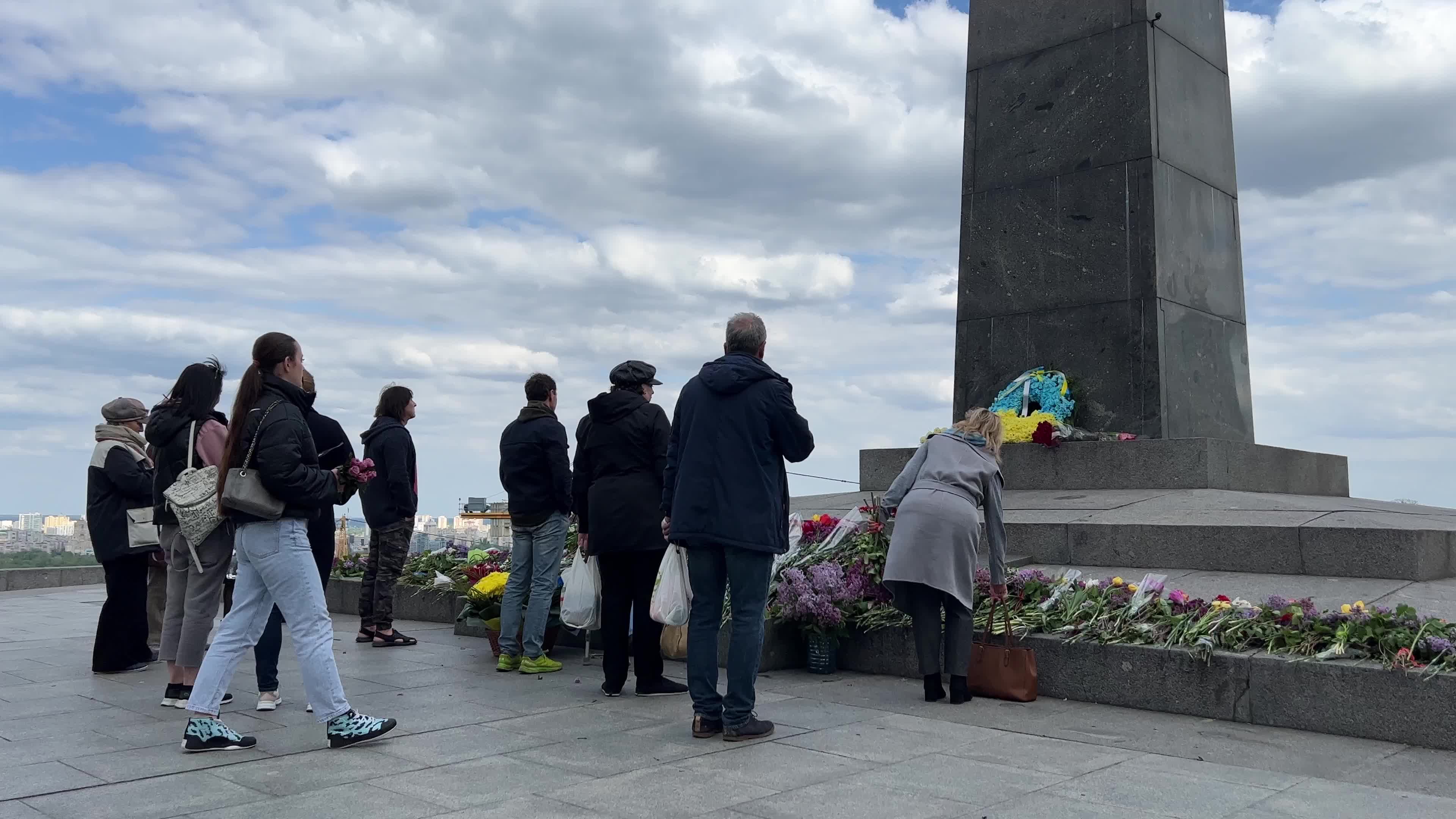 People place floral tributes at the Tomb of the Unknown Soldier monument during Victory in WWII Day commemorations in Kyiv 
