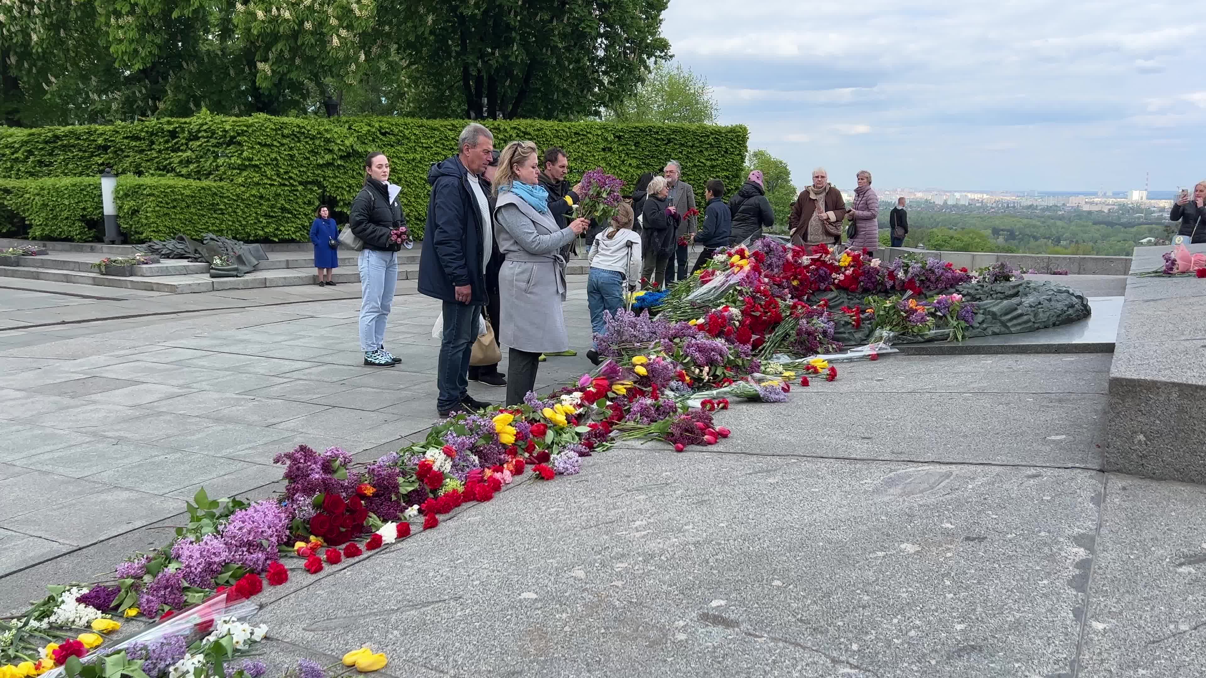 People place floral tributes at the Tomb of the Unknown Soldier monument during Victory in WWII Day commemorations in Kyiv 