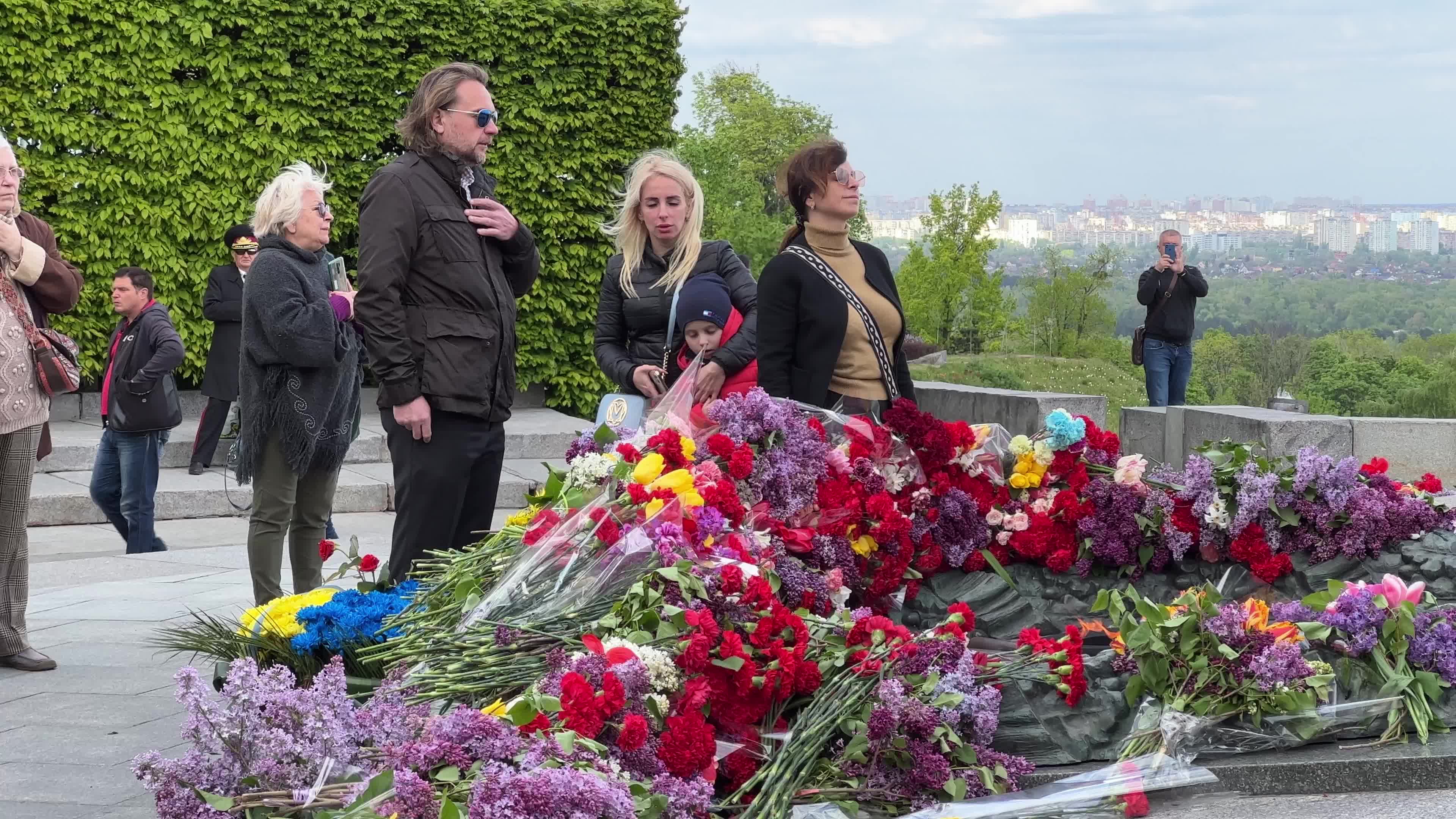 People place floral tributes at the Tomb of the Unknown Soldier monument during Victory in WWII Day commemorations in Kyiv 