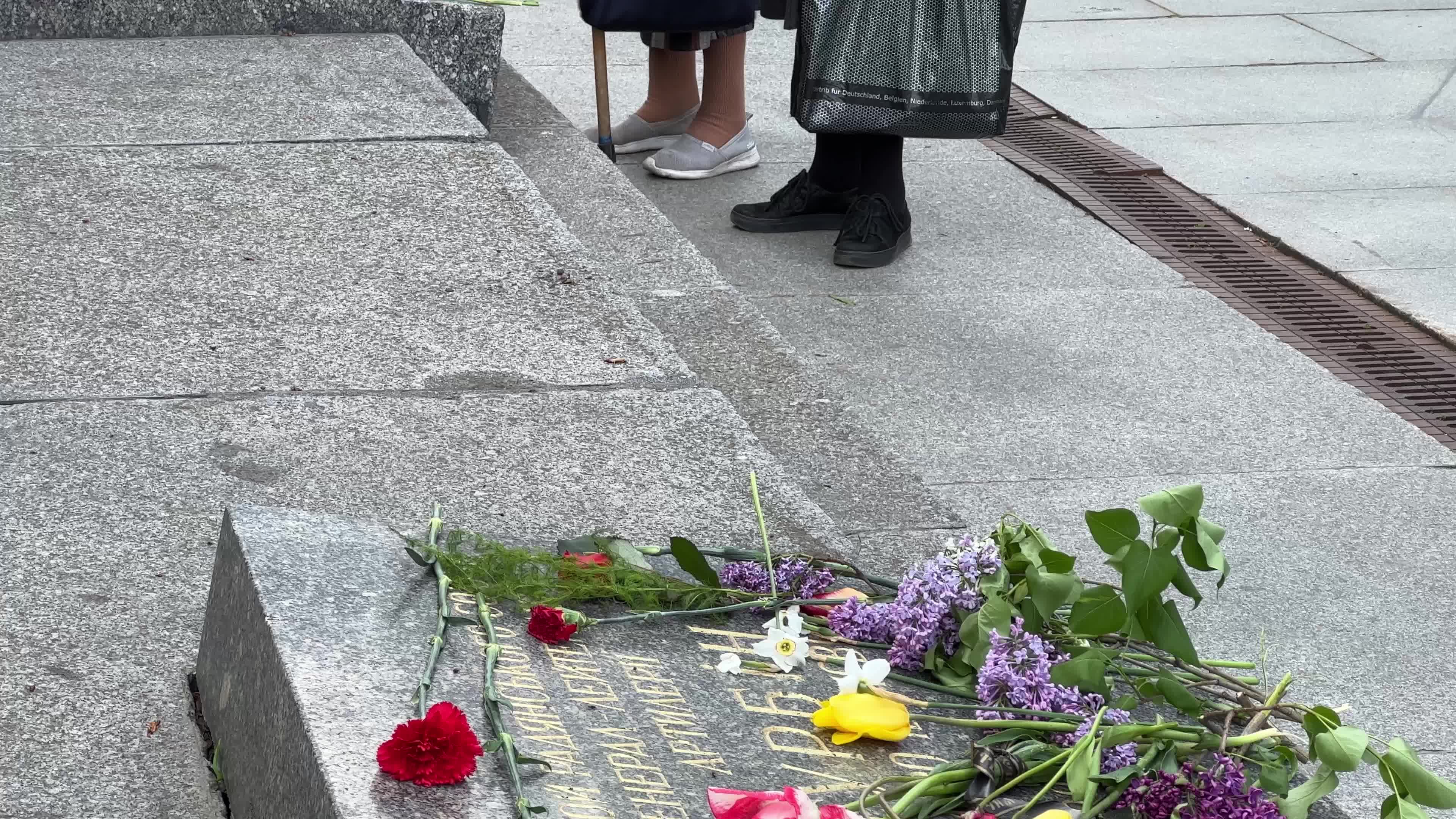 People place floral tributes at the Tomb of the Unknown Soldier monument during Victory in WWII Day commemorations in Kyiv 