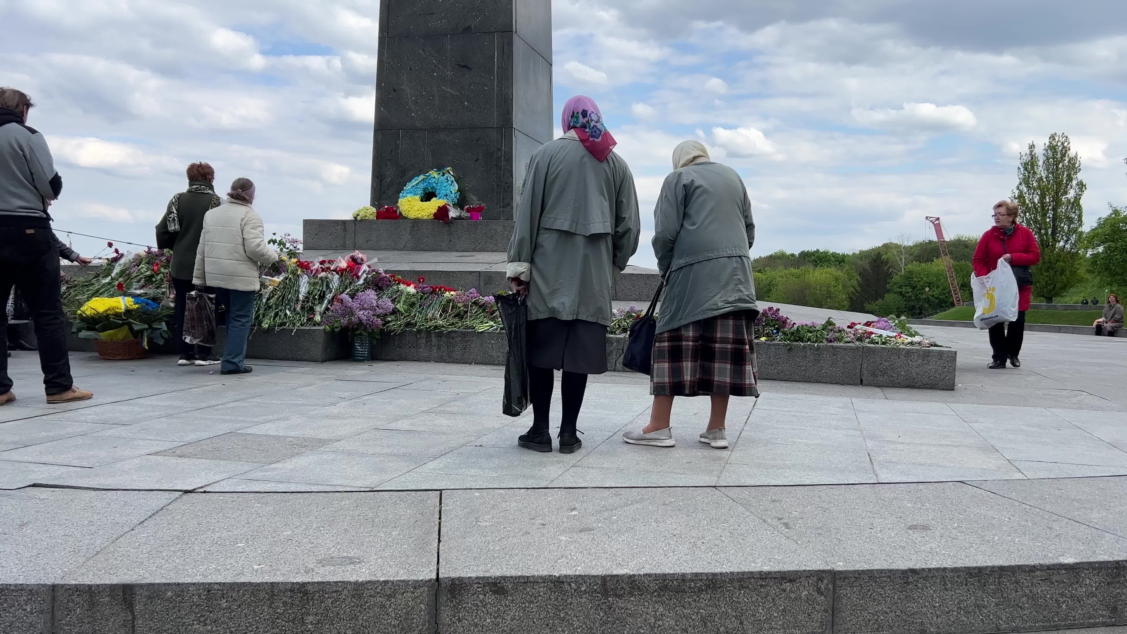 People place floral tributes at the Tomb of the Unknown Soldier monument during Victory in WWII Day commemorations in Kyiv 