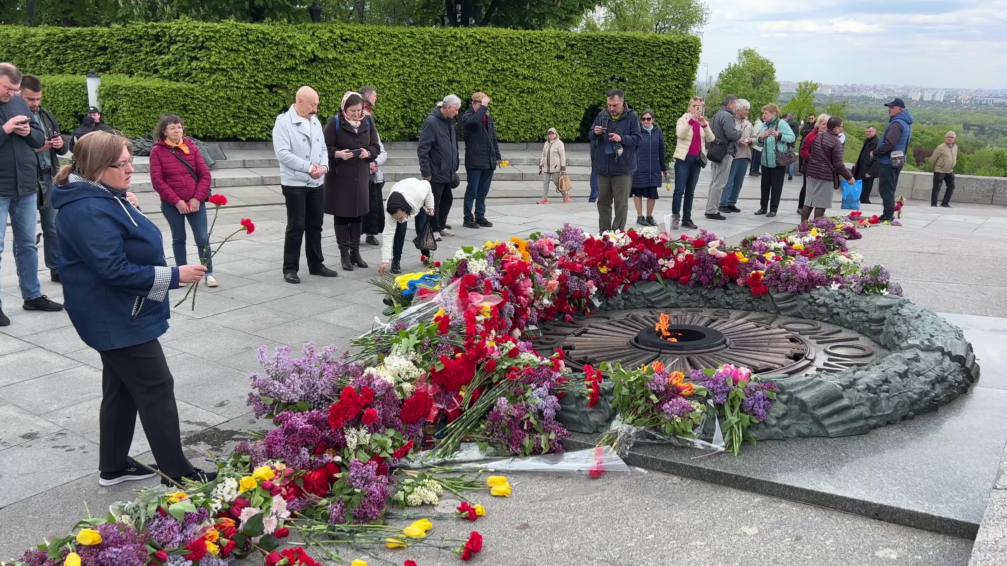 People place floral tributes at the Tomb of the Unknown Soldier monument during Victory in WWII Day commemorations in Kyiv 
