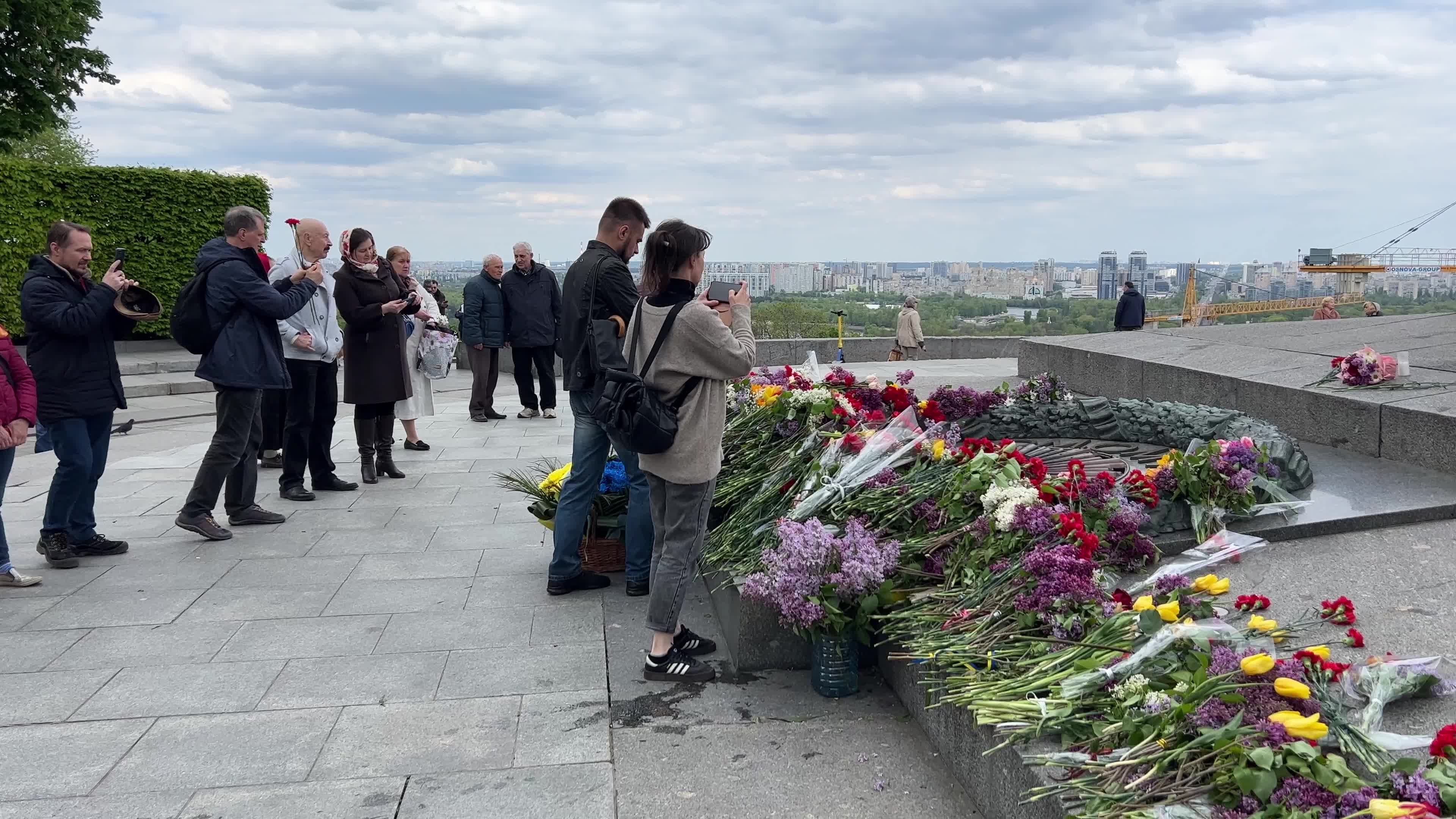 People place floral tributes at the Tomb of the Unknown Soldier monument during Victory in WWII Day commemorations in Kyiv 