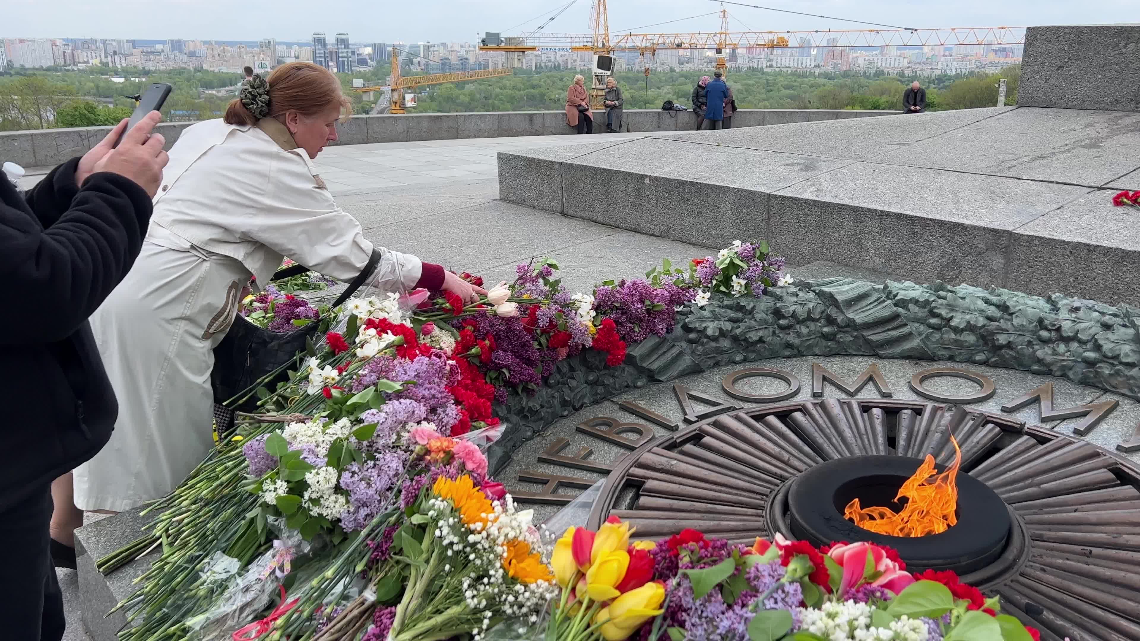 People place floral tributes at the Tomb of the Unknown Soldier monument during Victory in WWII Day commemorations in Kyiv 