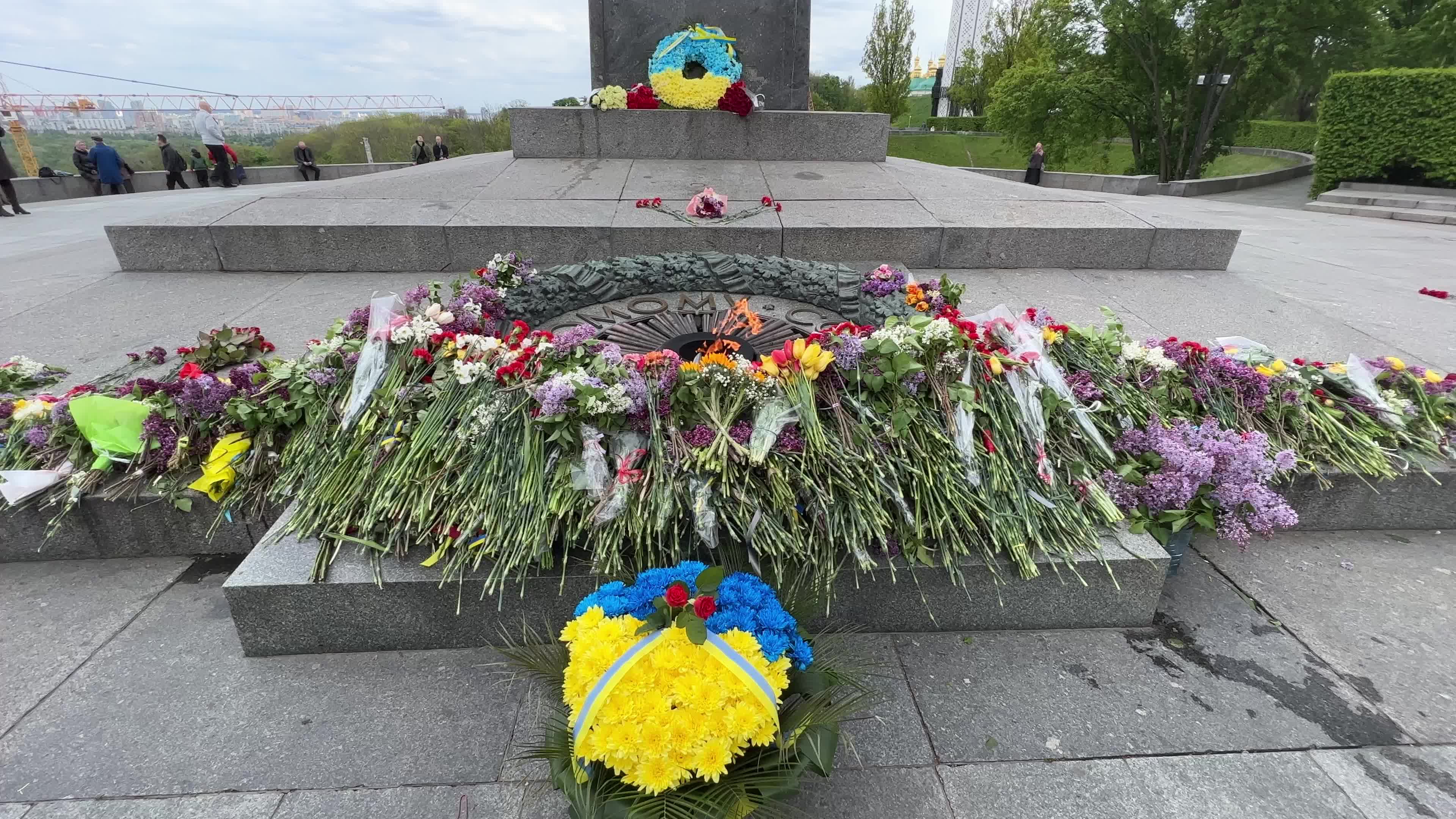 People place floral tributes at the Tomb of the Unknown Soldier monument during Victory in WWII Day commemorations in Kyiv 