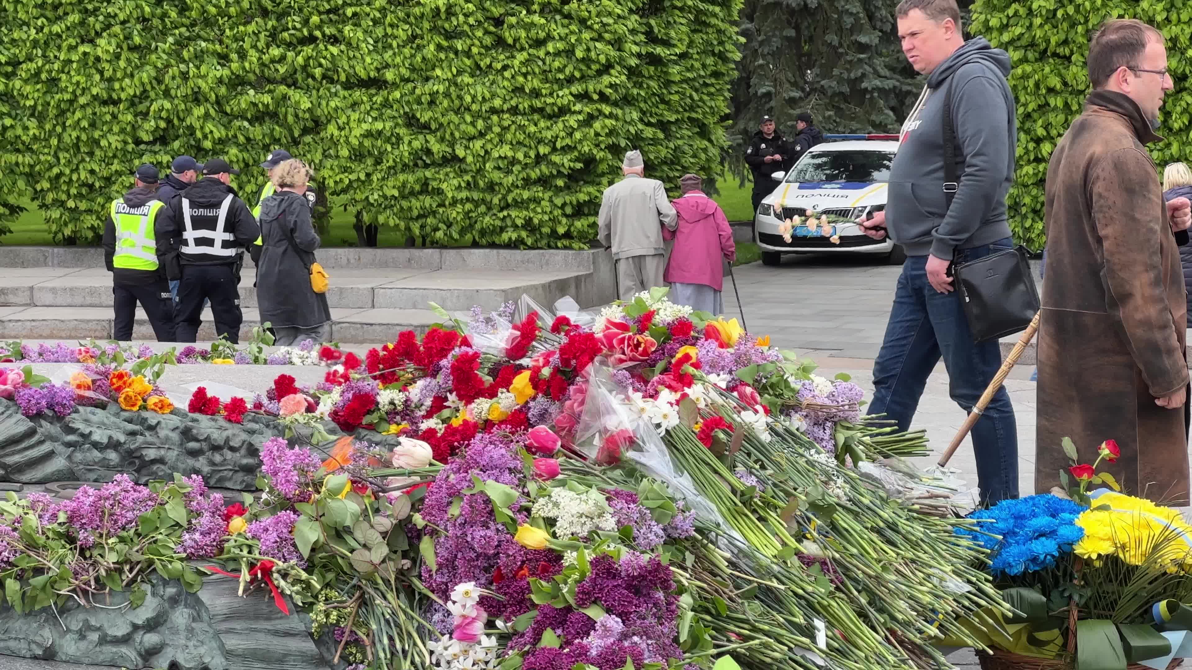 People place floral tributes at the Tomb of the Unknown Soldier monument during Victory in WWII Day commemorations in Kyiv 