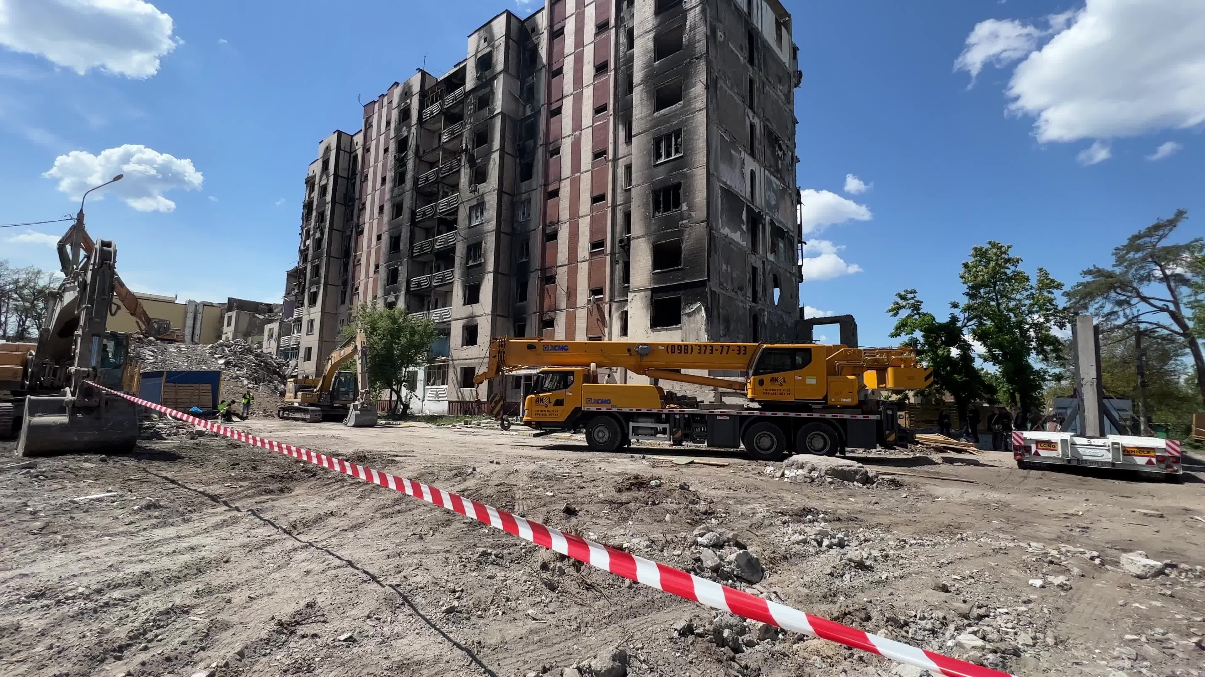Workers demolish a residential building heavily damaged during Russia's attack in the town of Irpin, outside of Kyiv