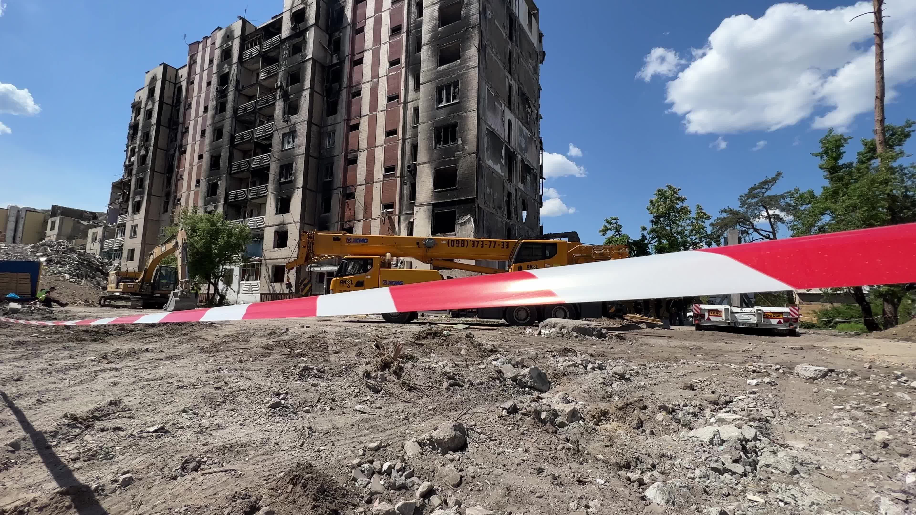 Workers demolish a residential building heavily damaged during Russia's attack in the town of Irpin, outside of Kyiv