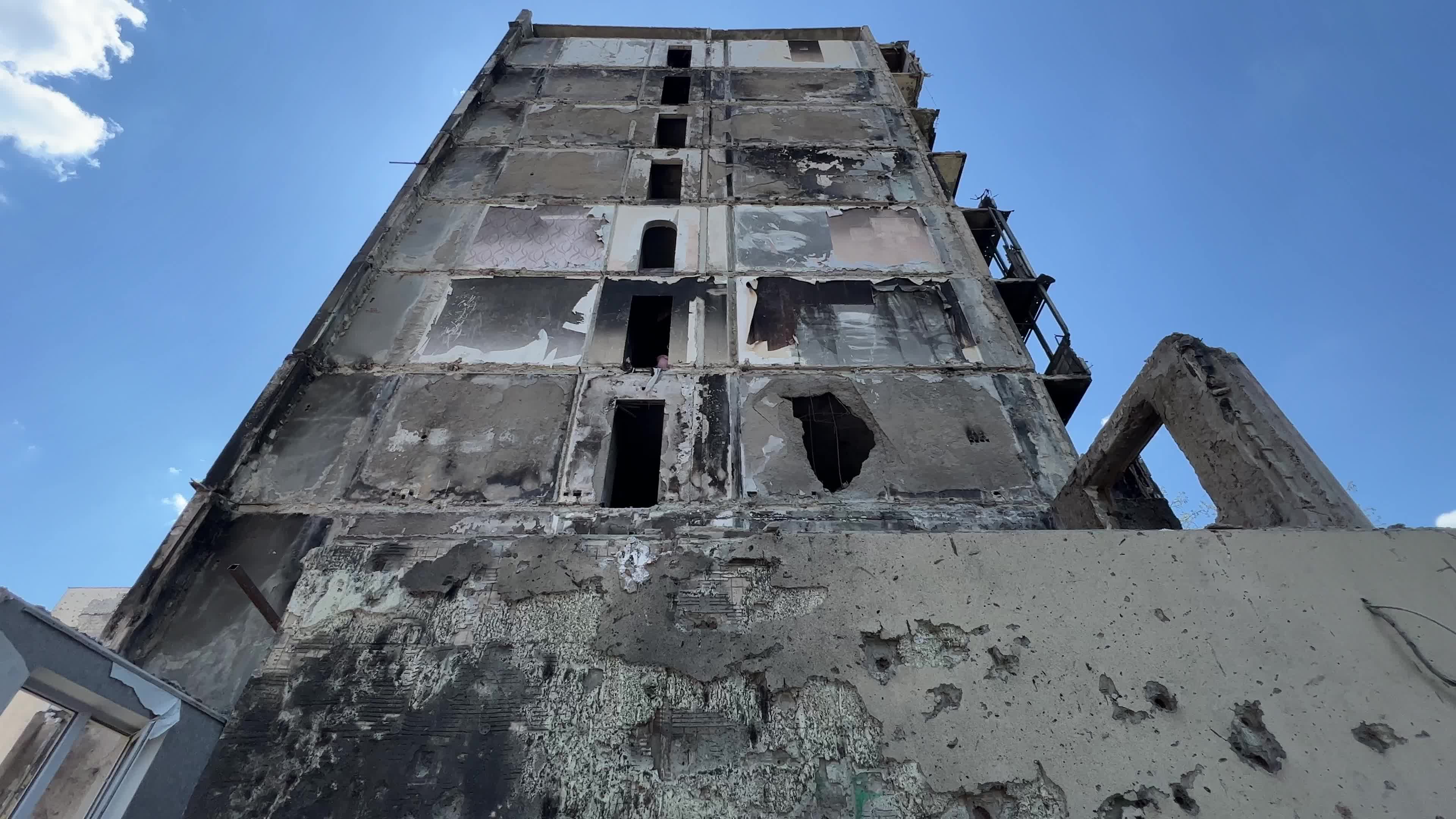 Workers demolish a residential building heavily damaged during Russia's attack in the town of Irpin, outside of Kyiv