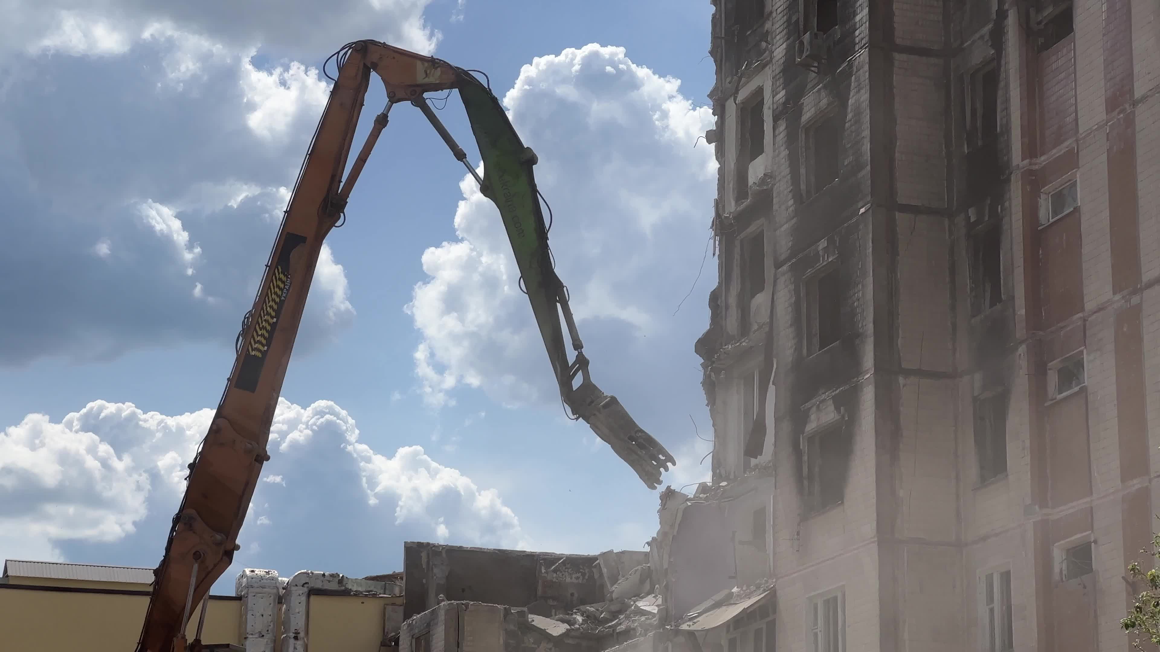 Workers demolish a residential building heavily damaged during Russia's attack in the town of Irpin, outside of Kyiv