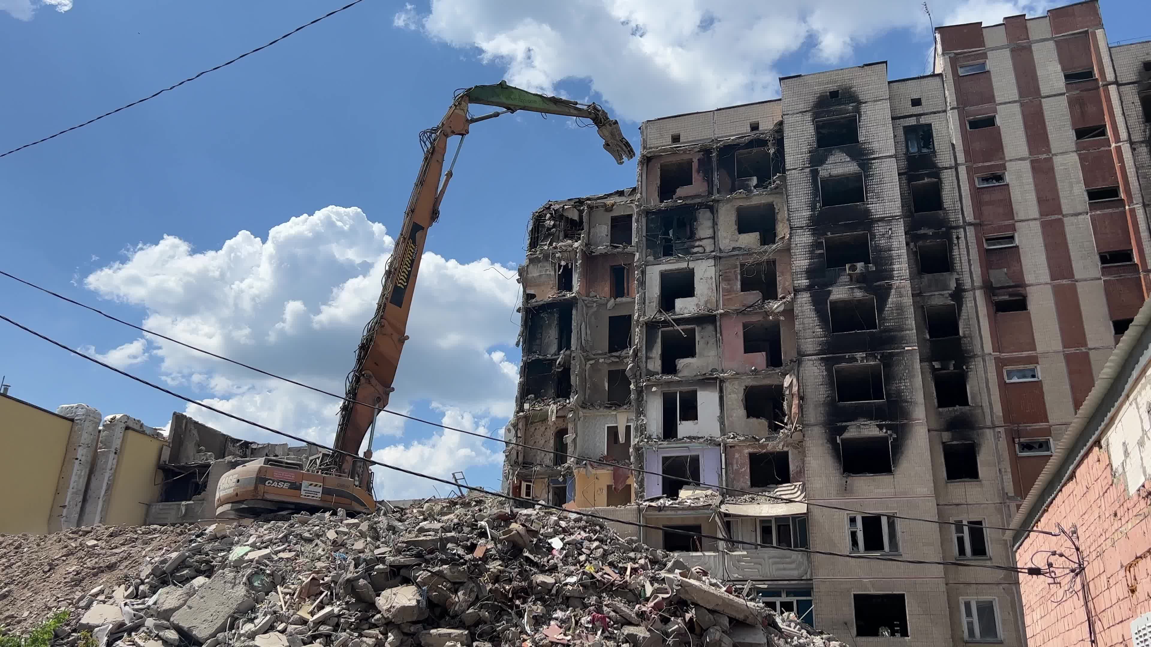 Workers demolish a residential building heavily damaged during Russia's attack in the town of Irpin, outside of Kyiv