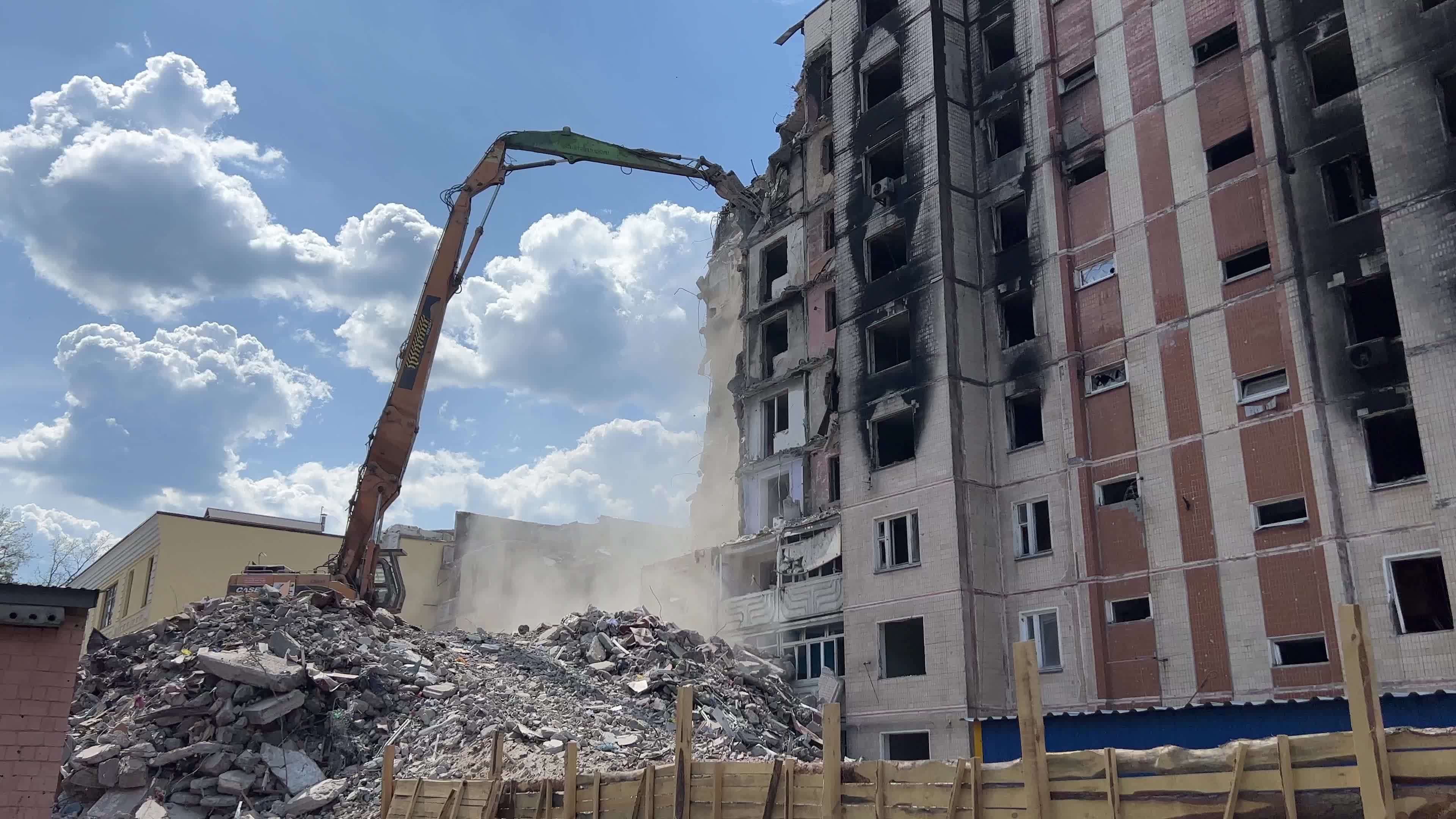 Workers demolish a residential building heavily damaged during Russia's attack in the town of Irpin, outside of Kyiv
