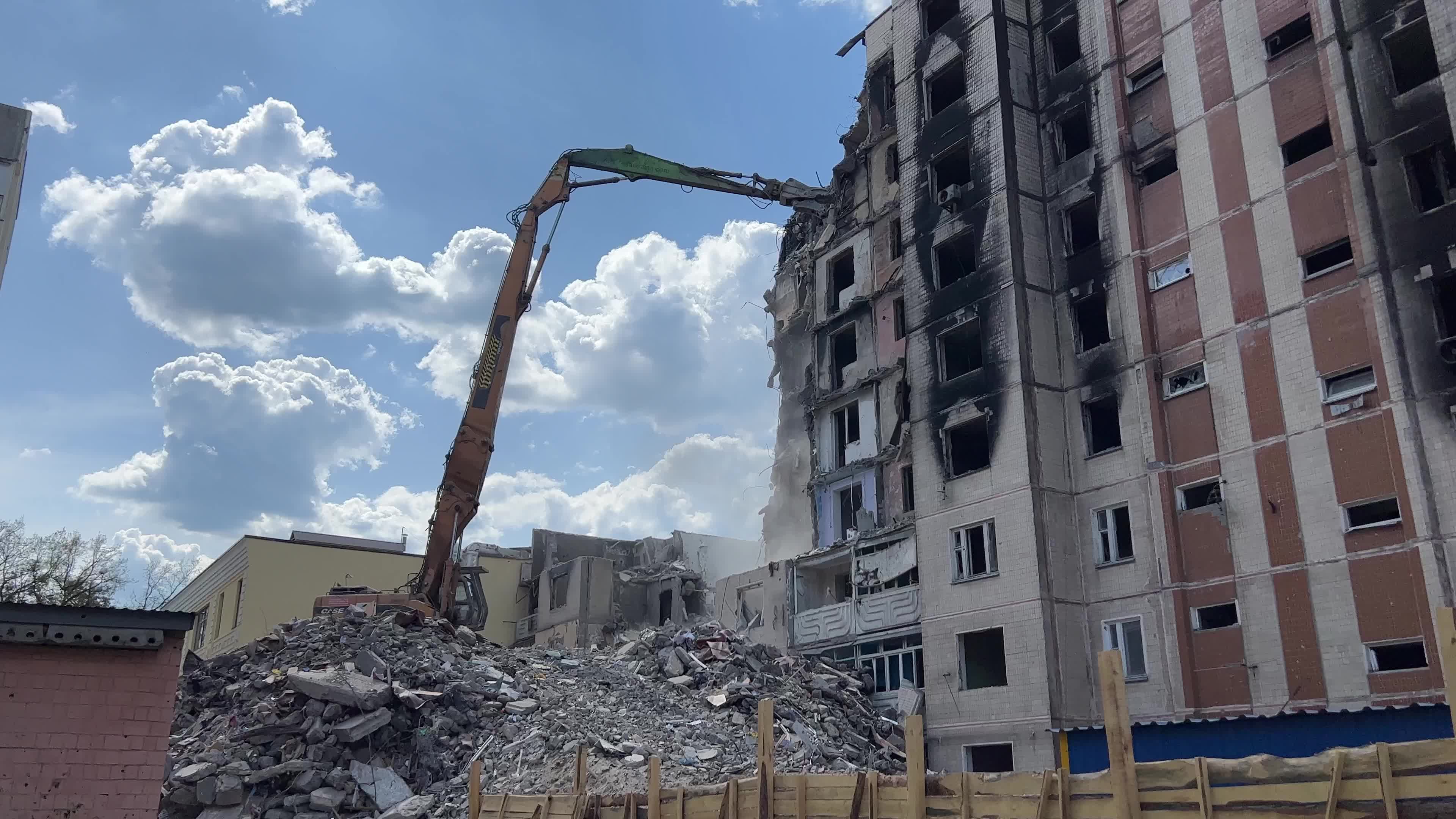 Workers demolish a residential building heavily damaged during Russia's attack in the town of Irpin, outside of Kyiv