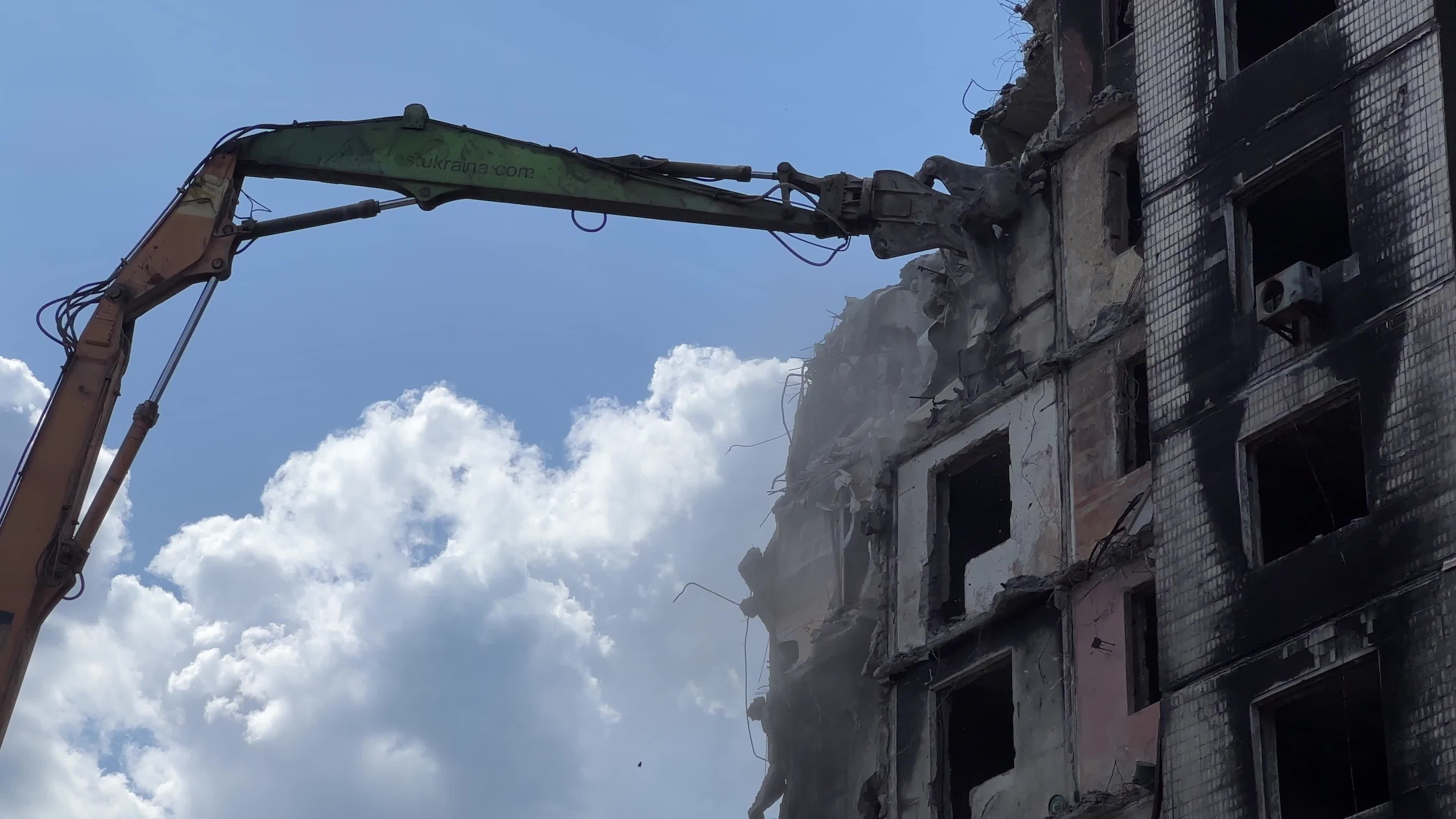 Workers demolish a residential building heavily damaged during Russia's attack in the town of Irpin, outside of Kyiv