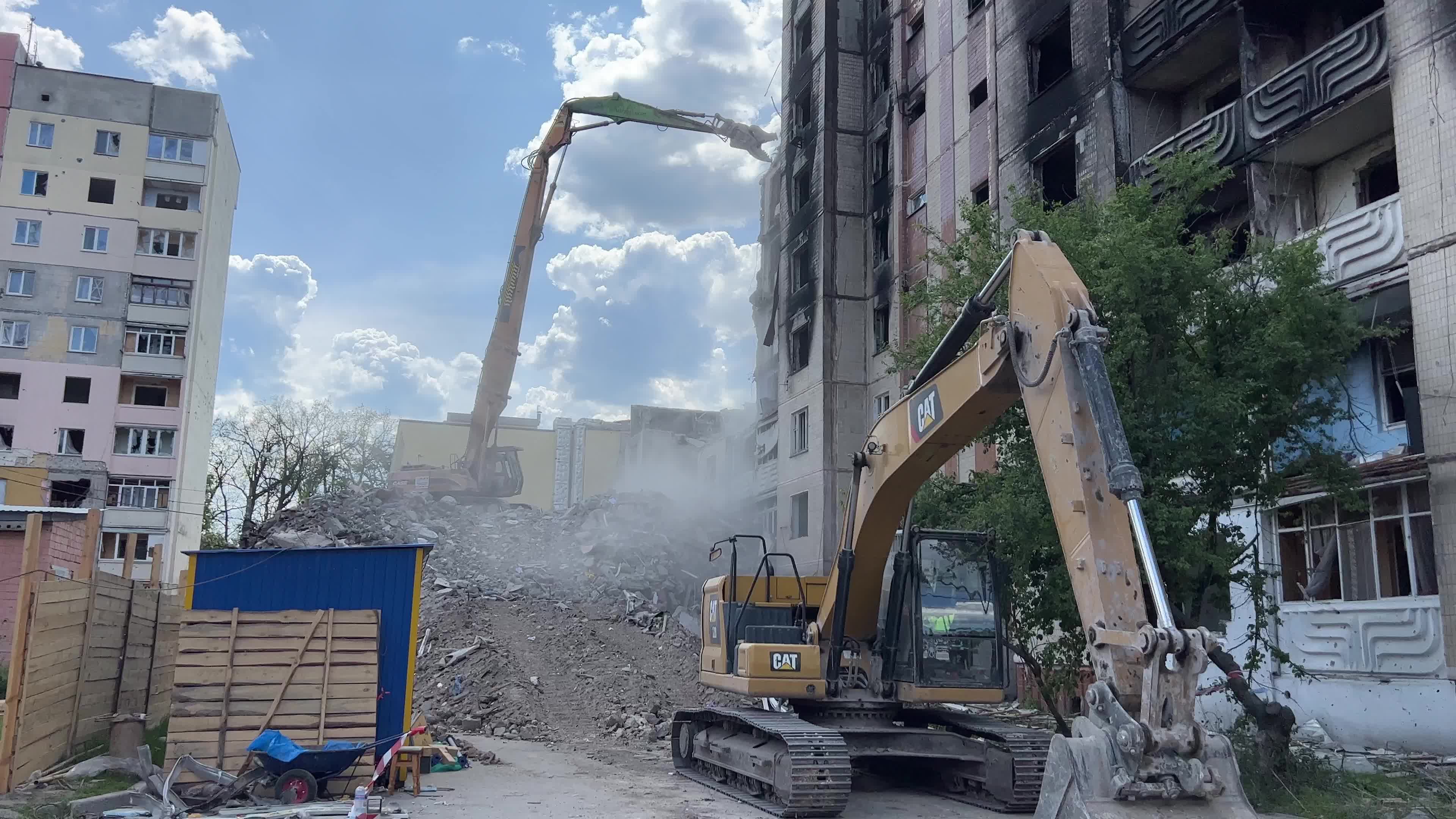 Workers demolish a residential building heavily damaged during Russia's attack in the town of Irpin, outside of Kyiv