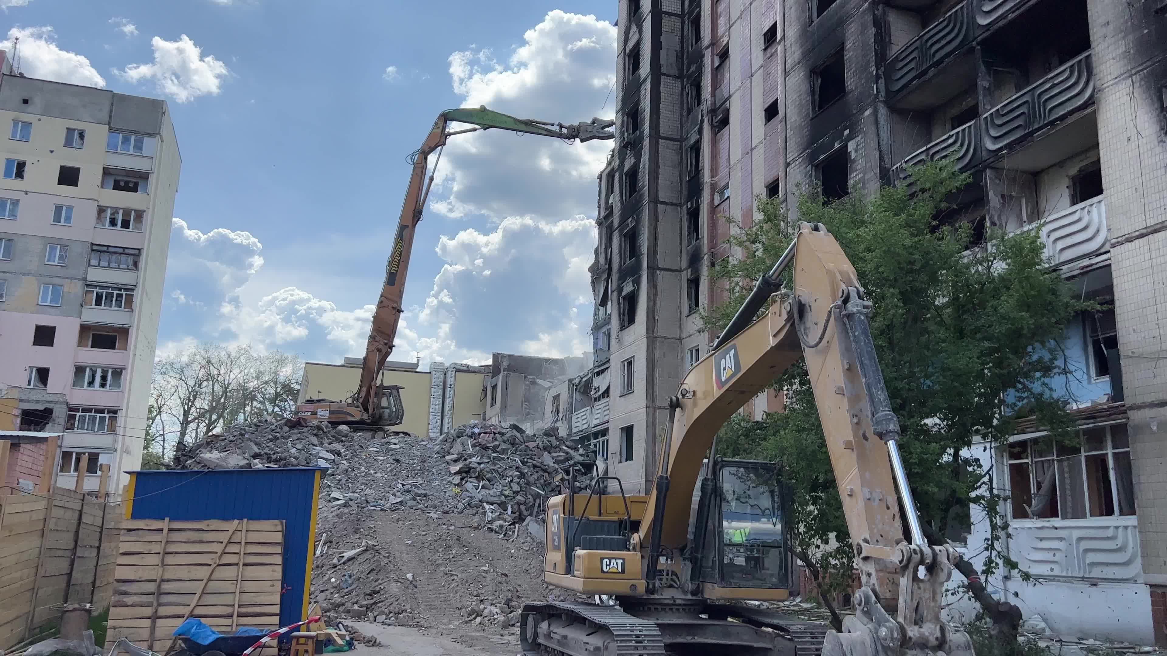 Workers demolish a residential building heavily damaged during Russia's attack in the town of Irpin, outside of Kyiv