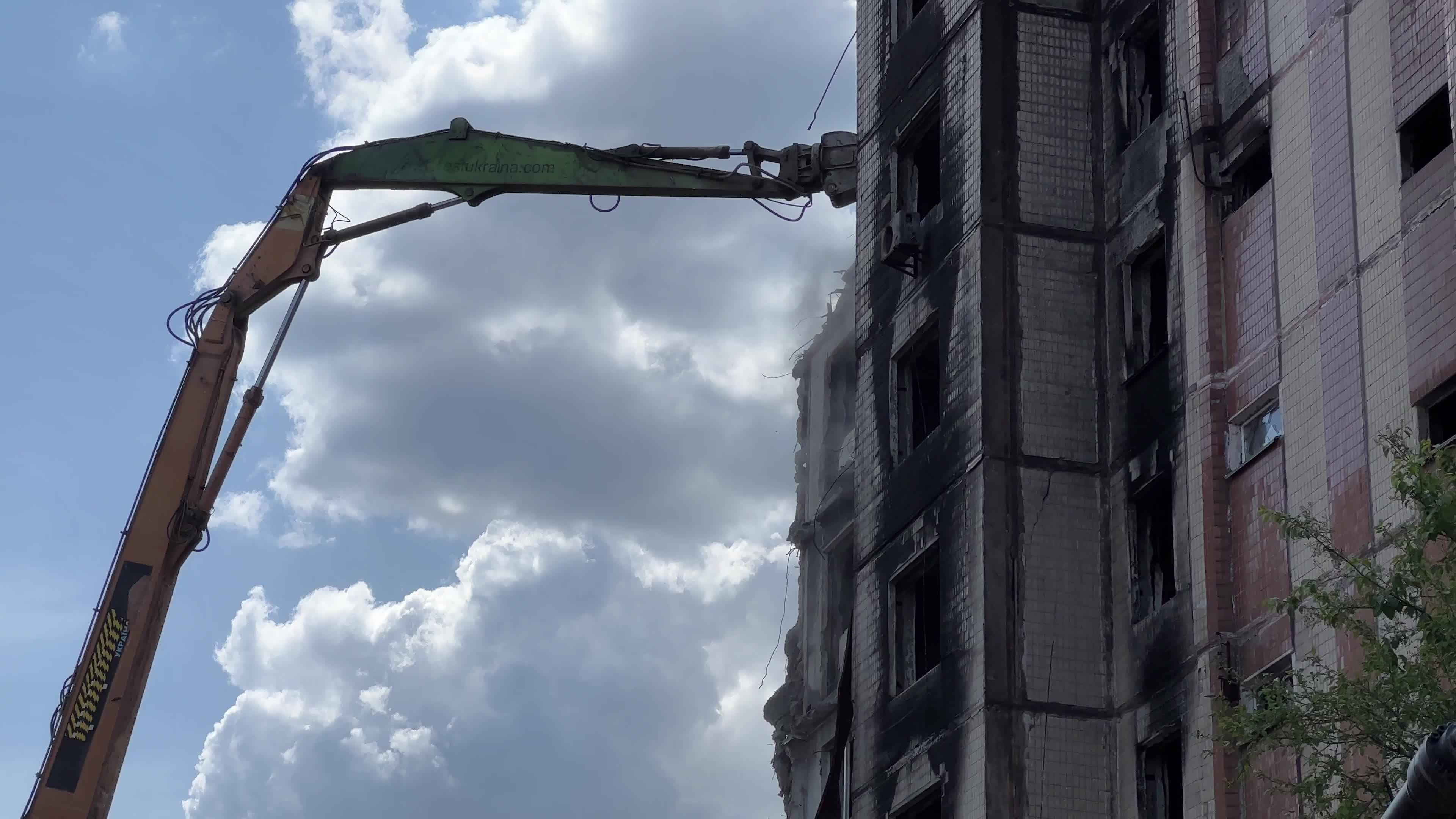 Workers demolish a residential building heavily damaged during Russia's attack in the town of Irpin, outside of Kyiv