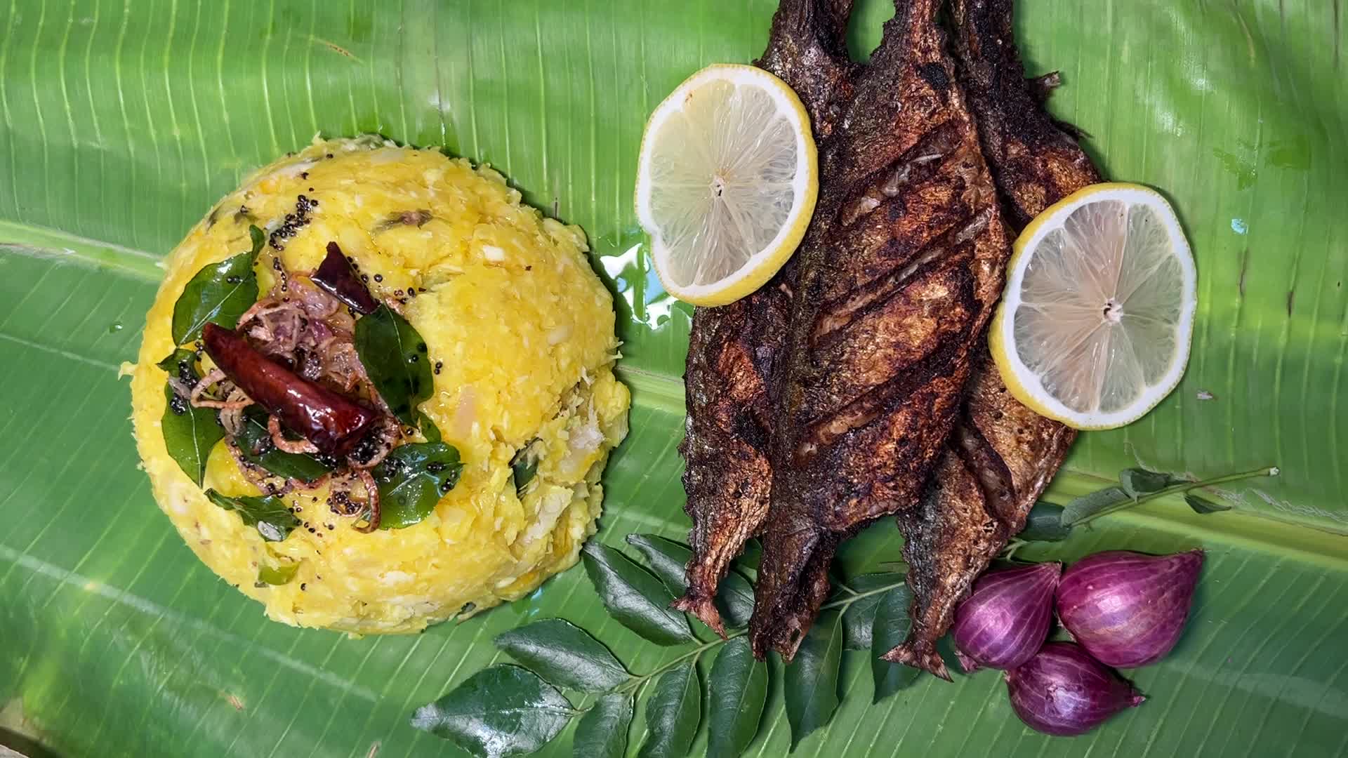 Kerala style fried fish with tapioca served on banana leaf