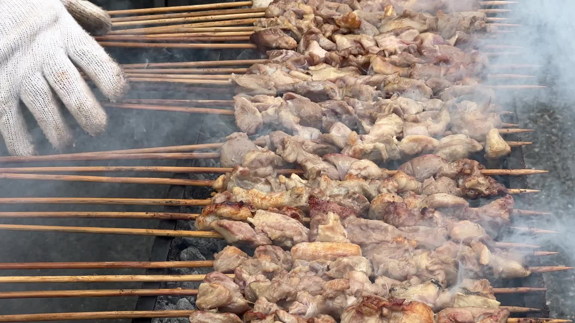 Man grills lamb skewers
