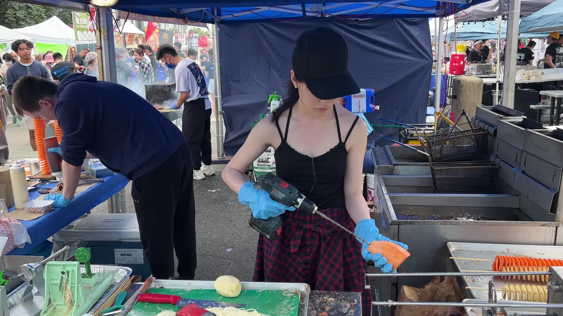 People prepare tornado potatoes during the Taste of Asia Food Festival