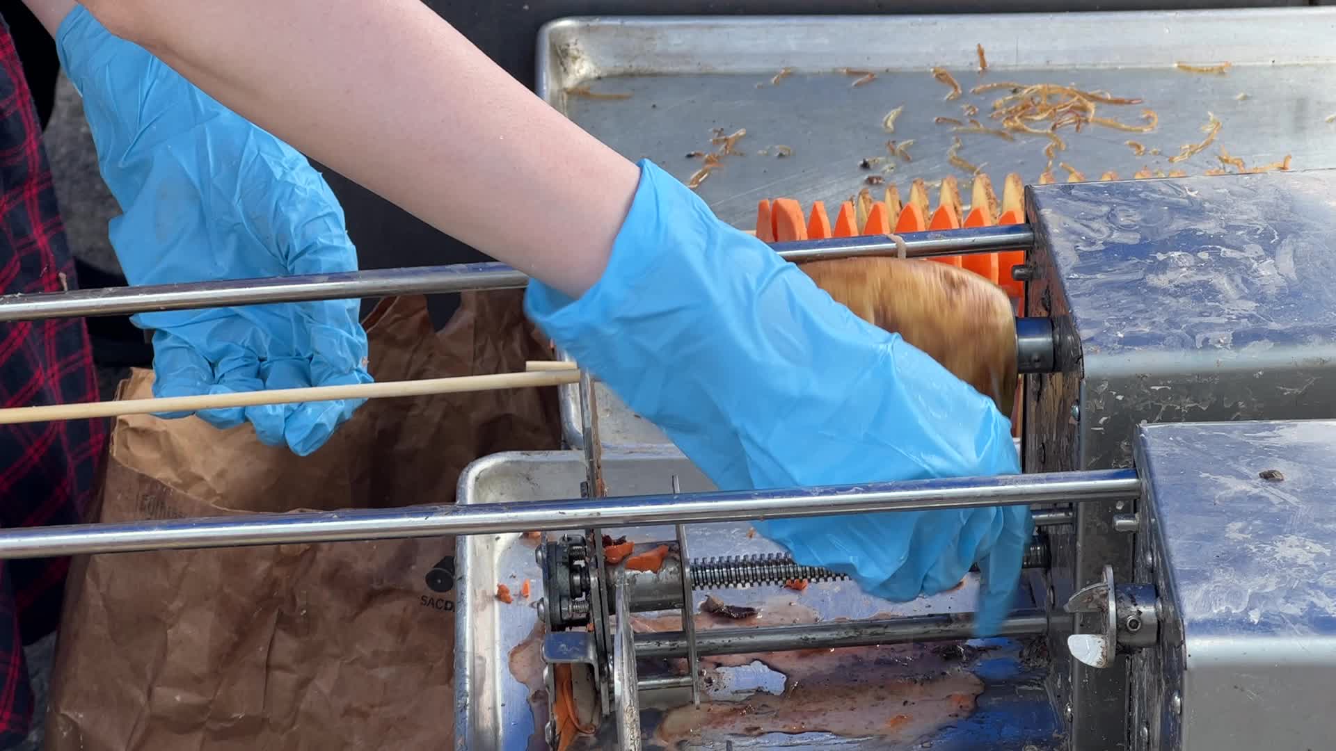 People prepare tornado potatoes during the Taste of Asia Food Festival