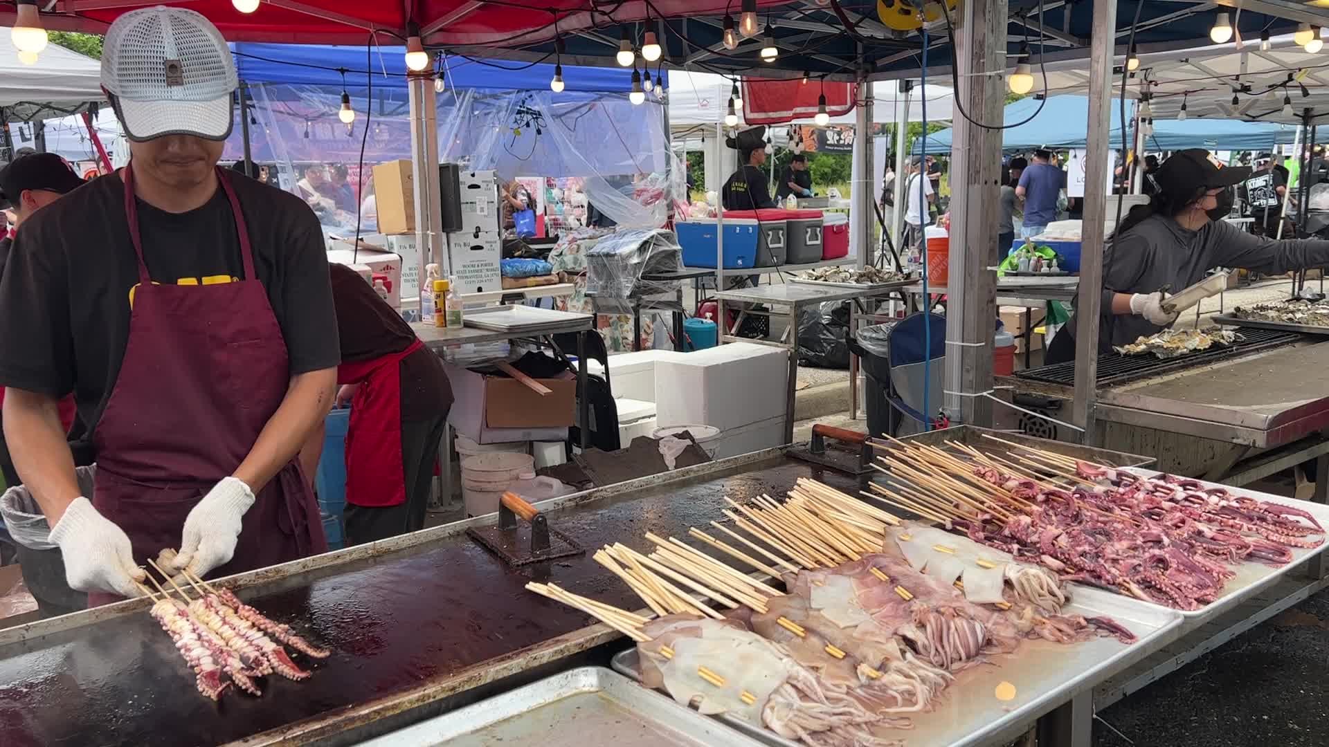 Man grills skewers of octopus tentacles
