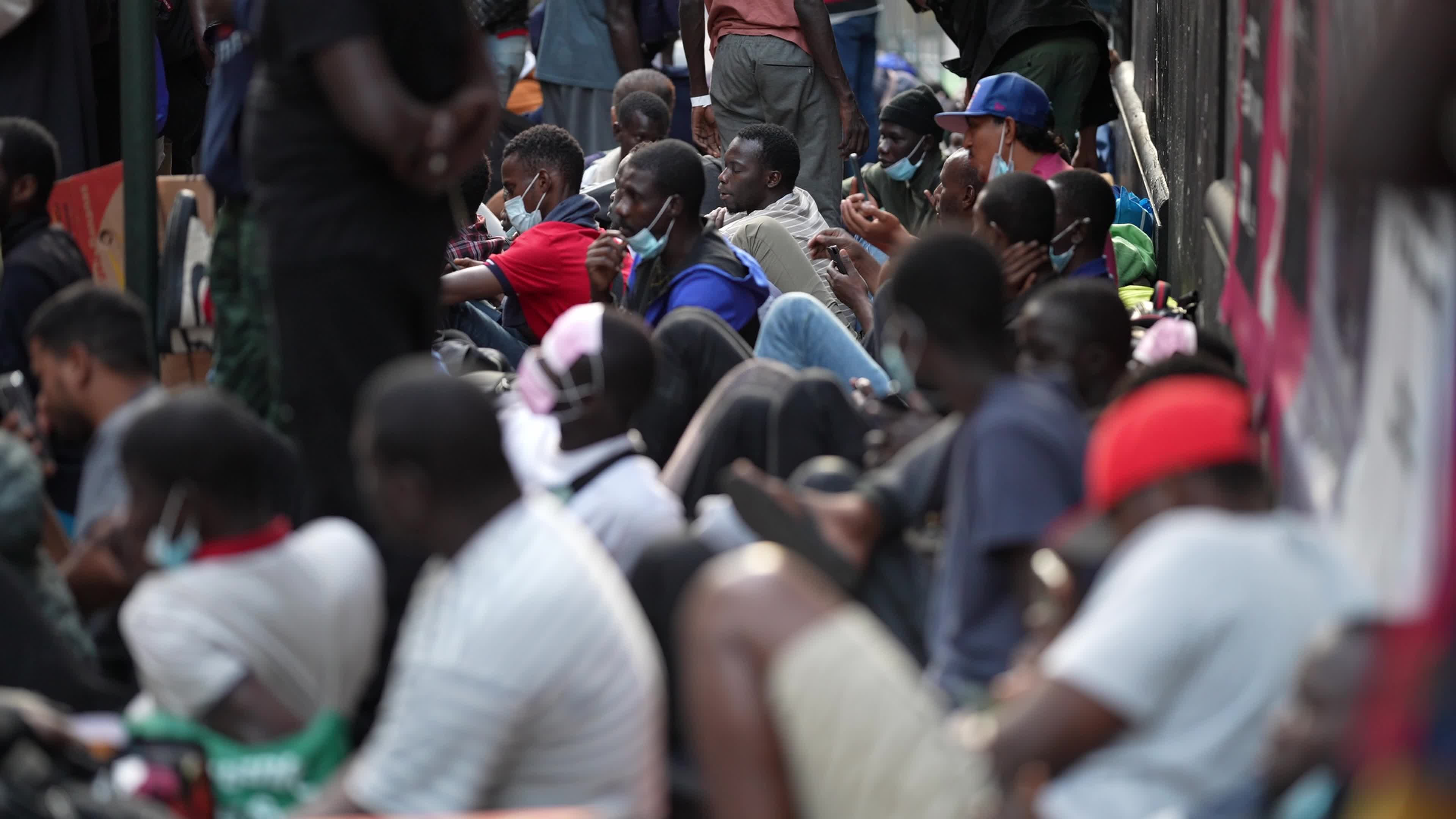 Asylum Seekers Line Up and Wait for Housing