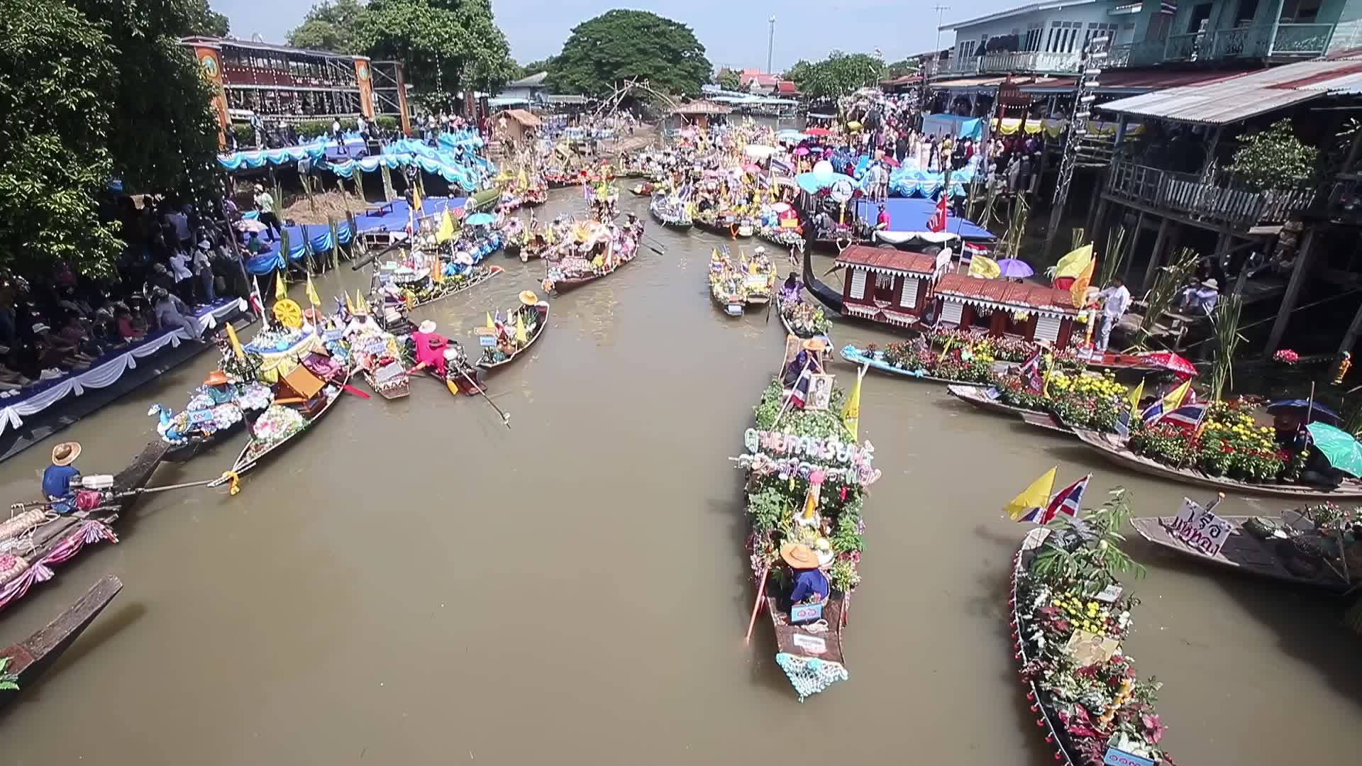 Boats carrying wax castles move along the Lat Chado canal