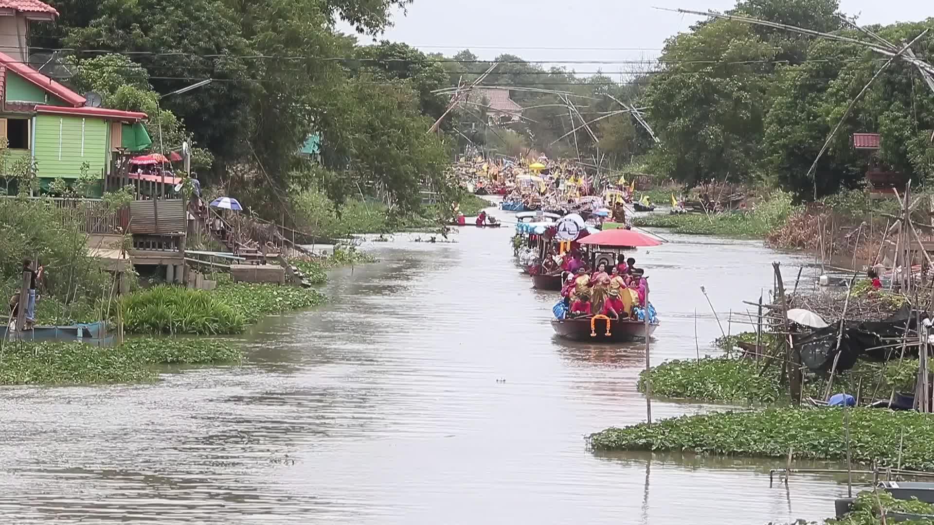 Boats carrying wax castles move along the Lat Chado canal