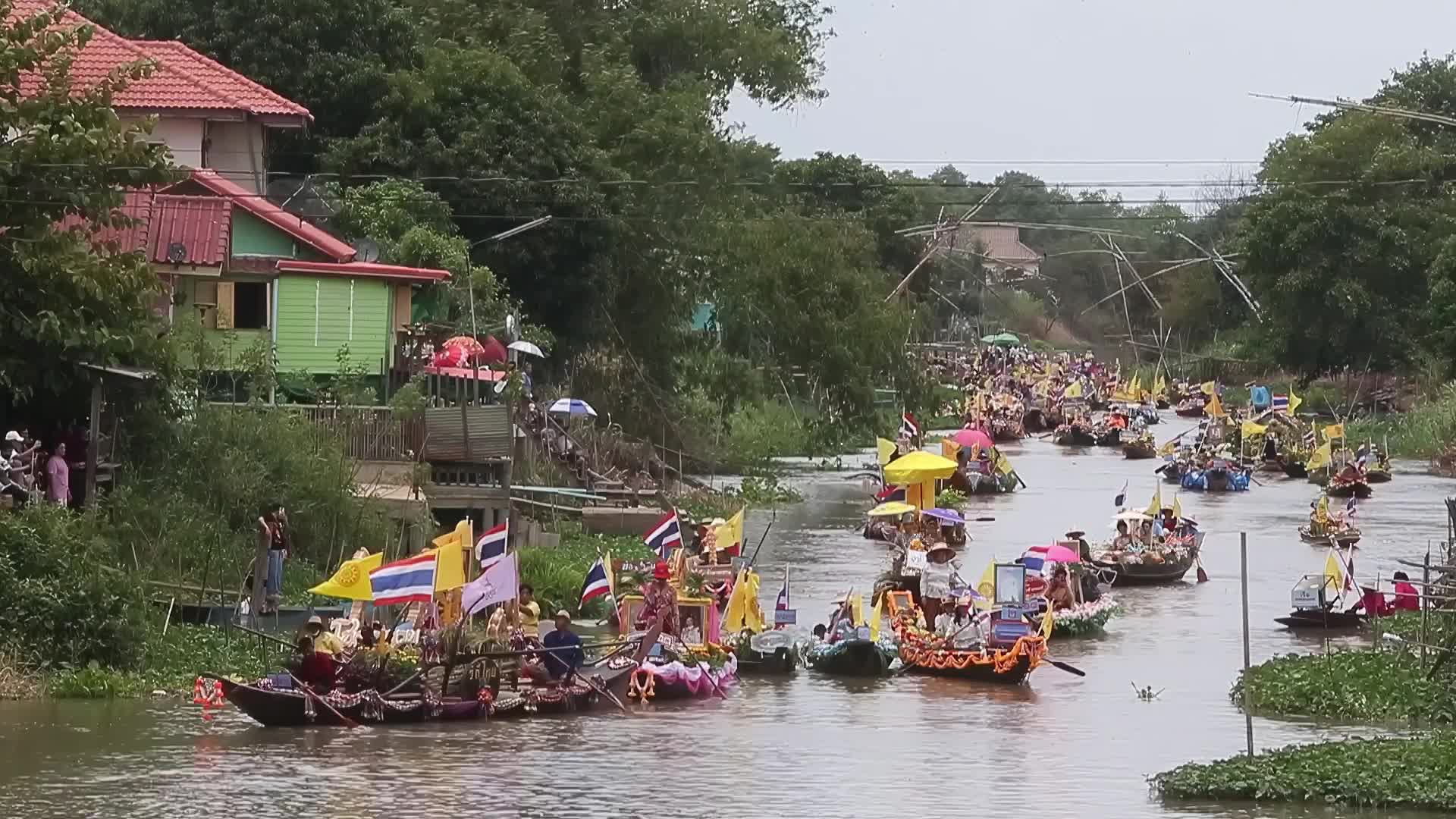 Boats carrying wax castles move along the Lat Chado canal