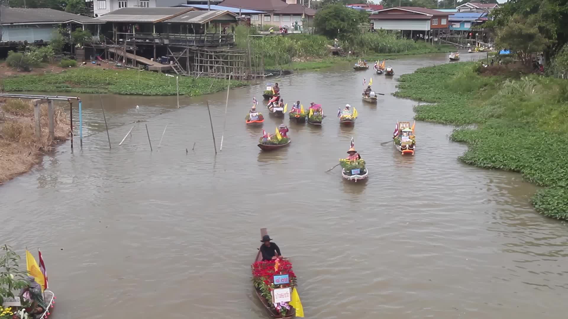 Boats carrying wax castles move along the Lat Chado canal