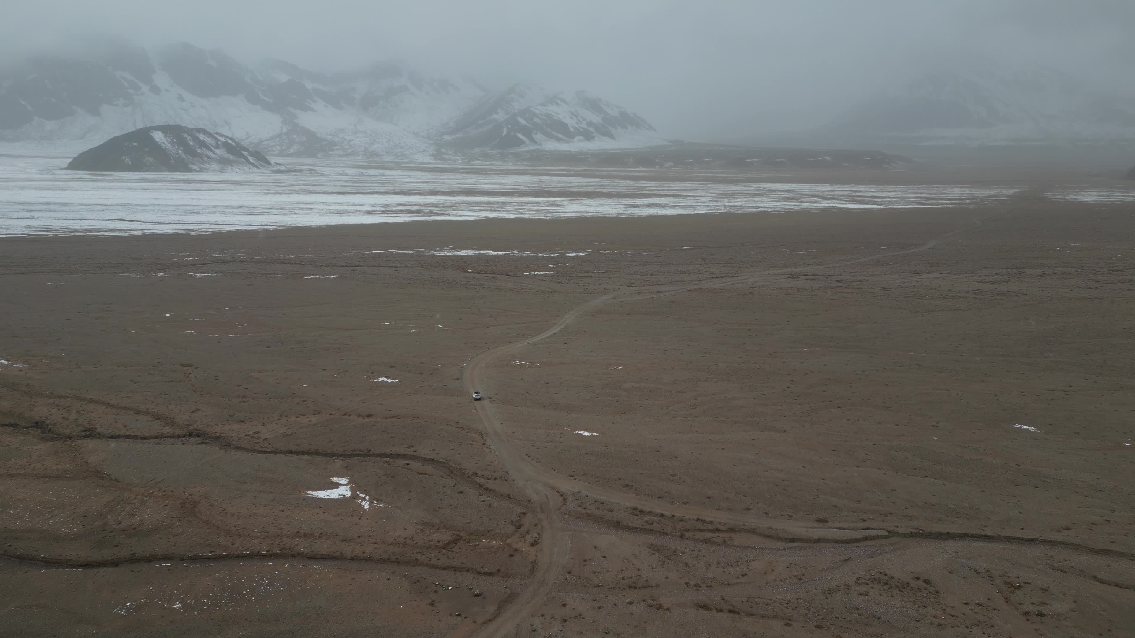 Car driving in the desolate landscape of Tajikistan