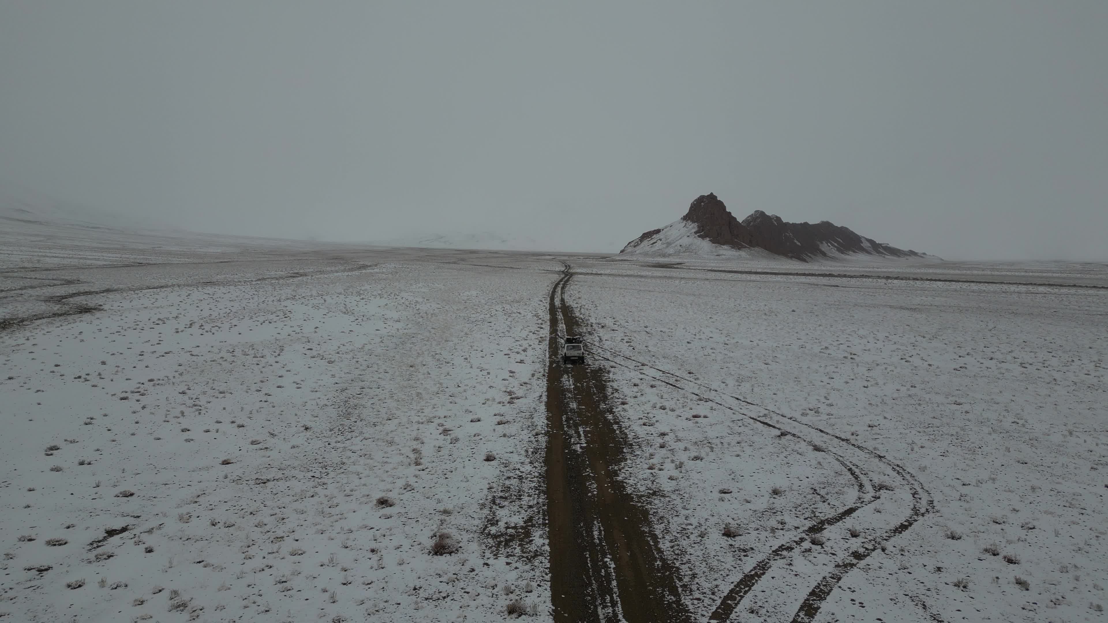 Car driving in the desolate landscape of Tajikistan