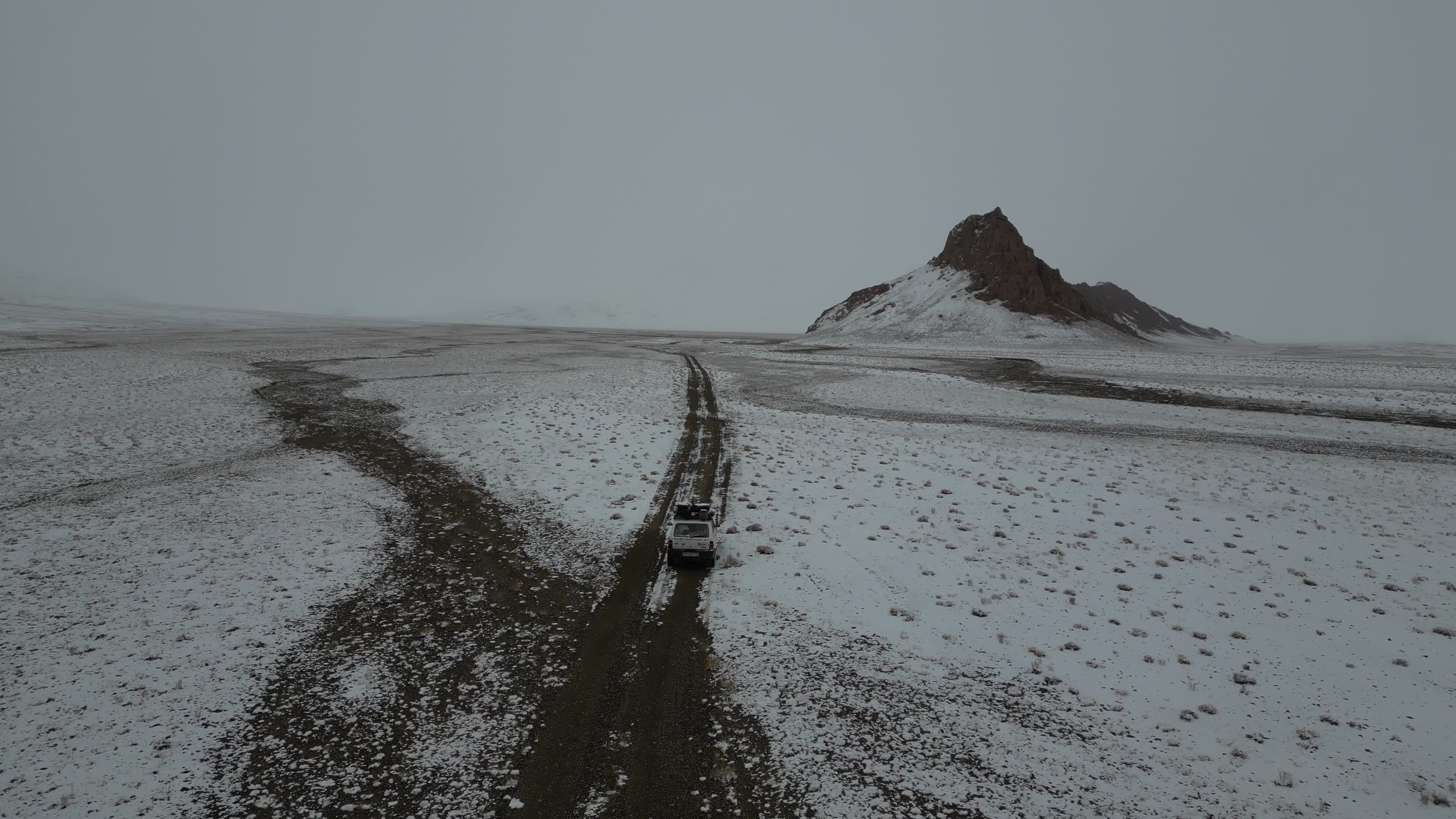 Car driving in the desolate landscape of Tajikistan
