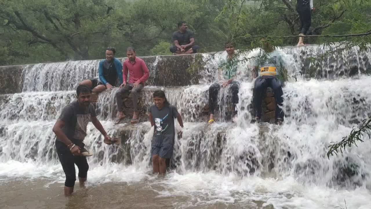 Tourists enjoy a bath at the waterfall during heavy monsoon rains in Pushkar, Rajasthan, India on August 17, 2019
