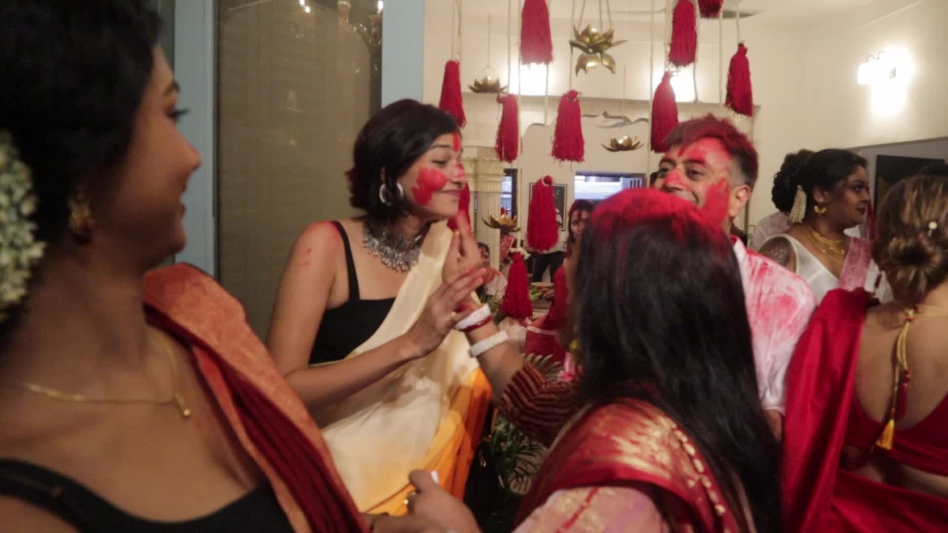 Men and women are smeared in red vermilion on the last day of Durgapuja 