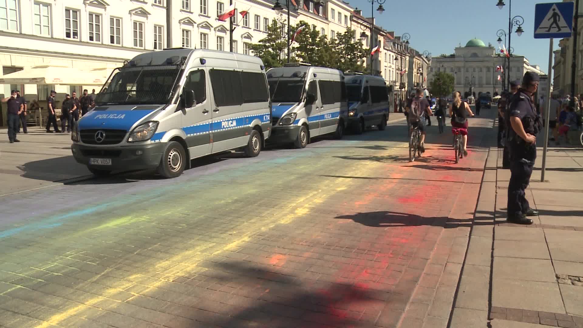 Police guarding rainbow flag painted on street in Warsaw