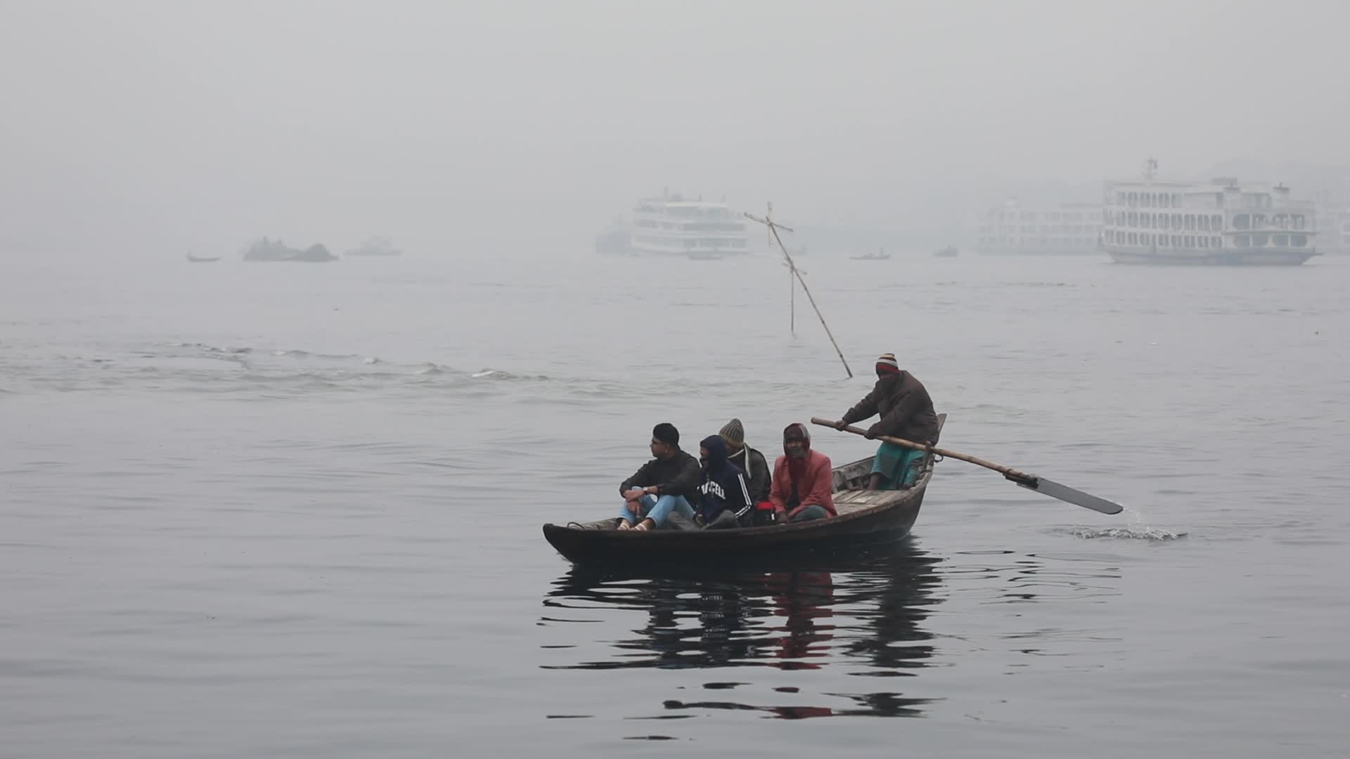Boatmen struggle to travel in the middle of the Buriganga River near Dhaka due to foggy weather