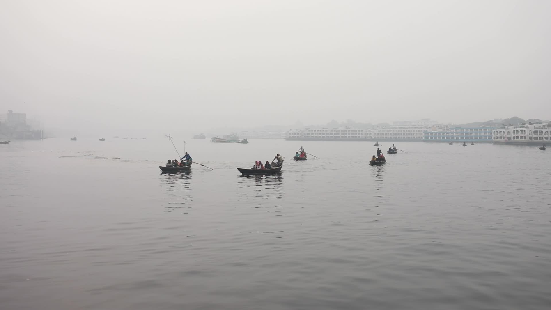 Boatmen struggle to travel in the middle of the Buriganga River near Dhaka due to foggy weather